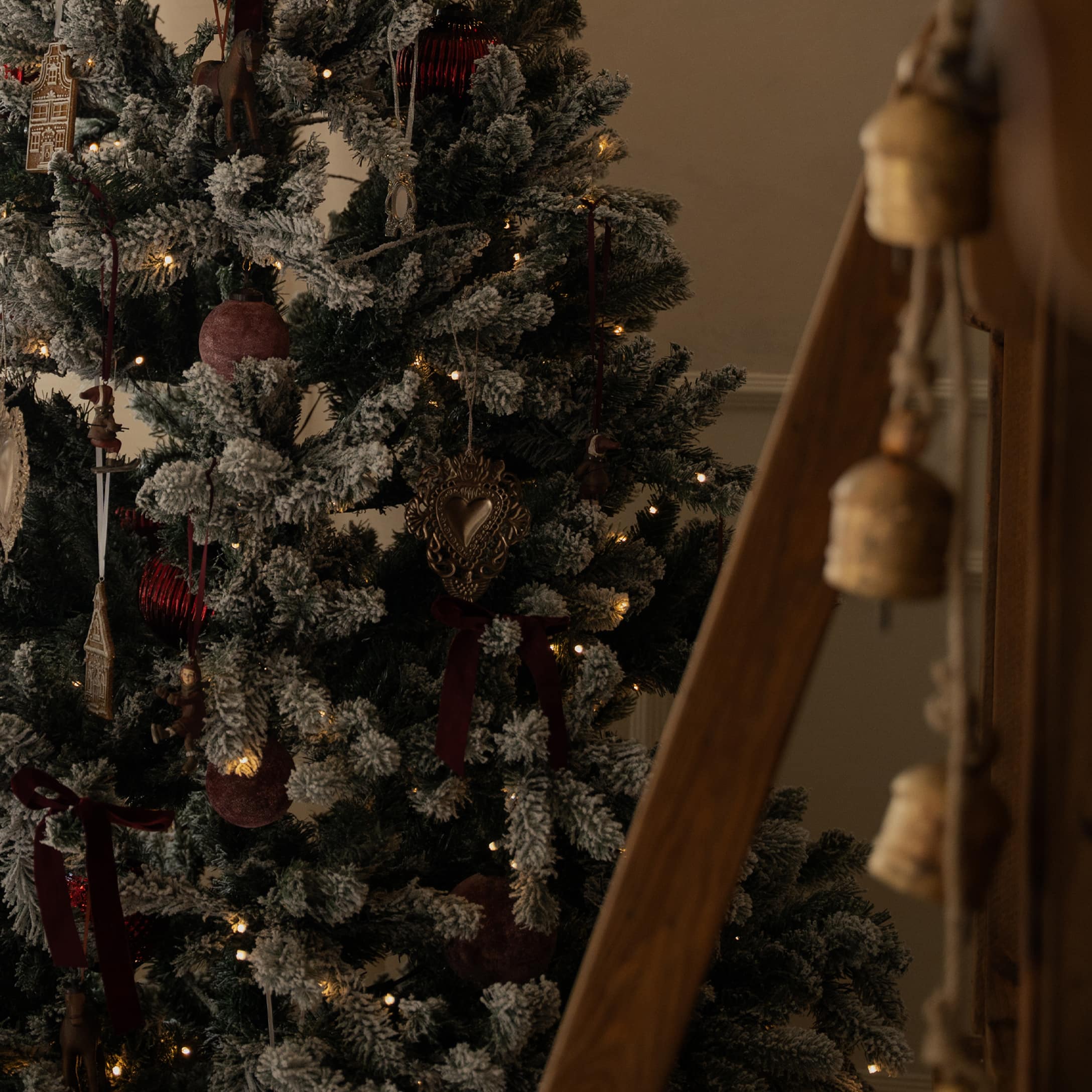 Sapin artificiel enneigé avec décorations rouges et guirlandes lumineuses LED douces