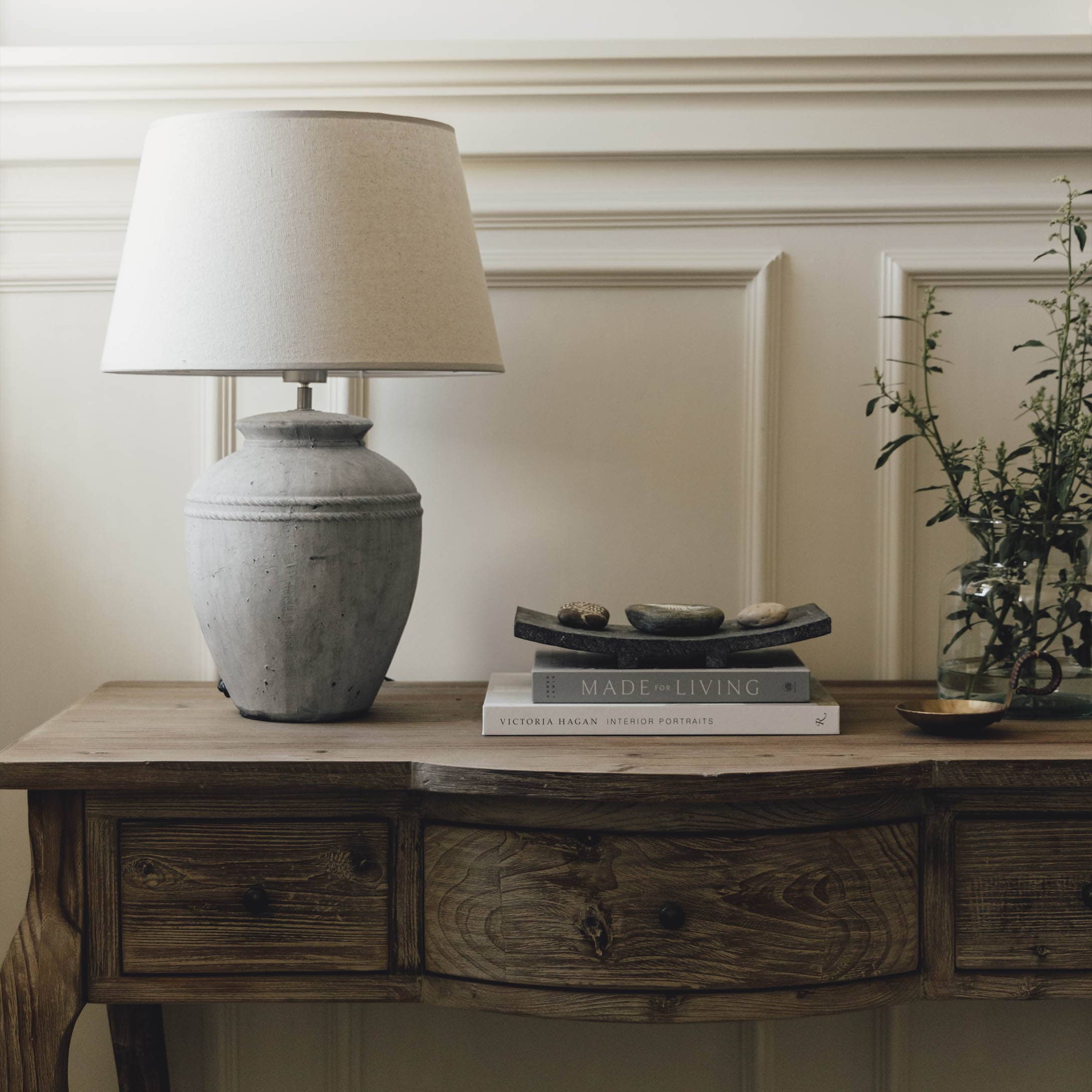 Lampe de table en céramique grise avec abat-jour beige sur une table en bois rustique