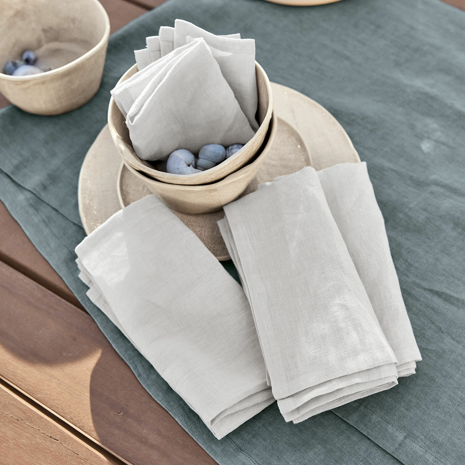 Lot de 4 serviettes Ghis Serviettes en lin blanc sur nappe verte avec bols en céramique et boules décoratives