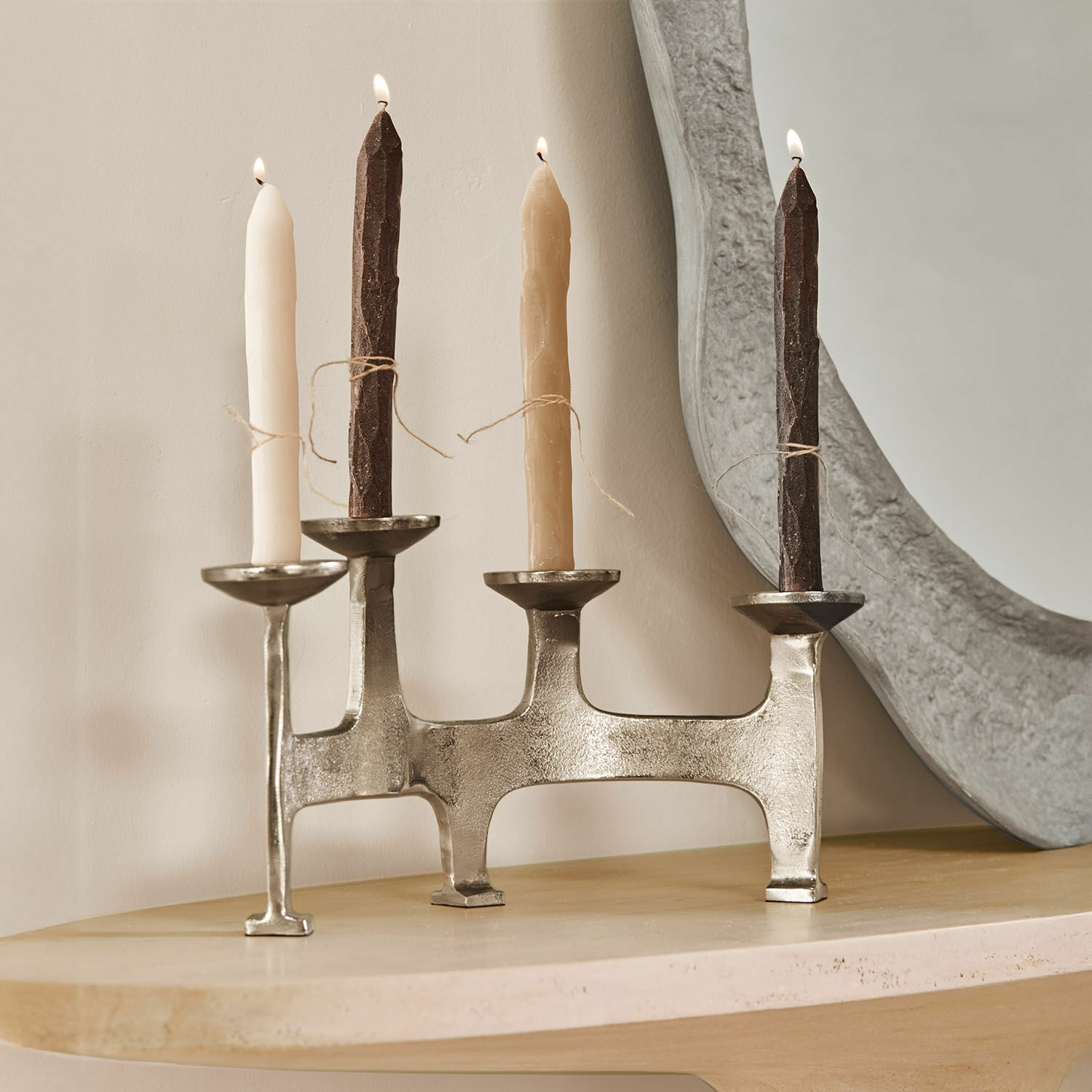 Bougeoir Tarimor Chandelier en métal pour quatre bougies avec bougies beige et marron sur une table en bois