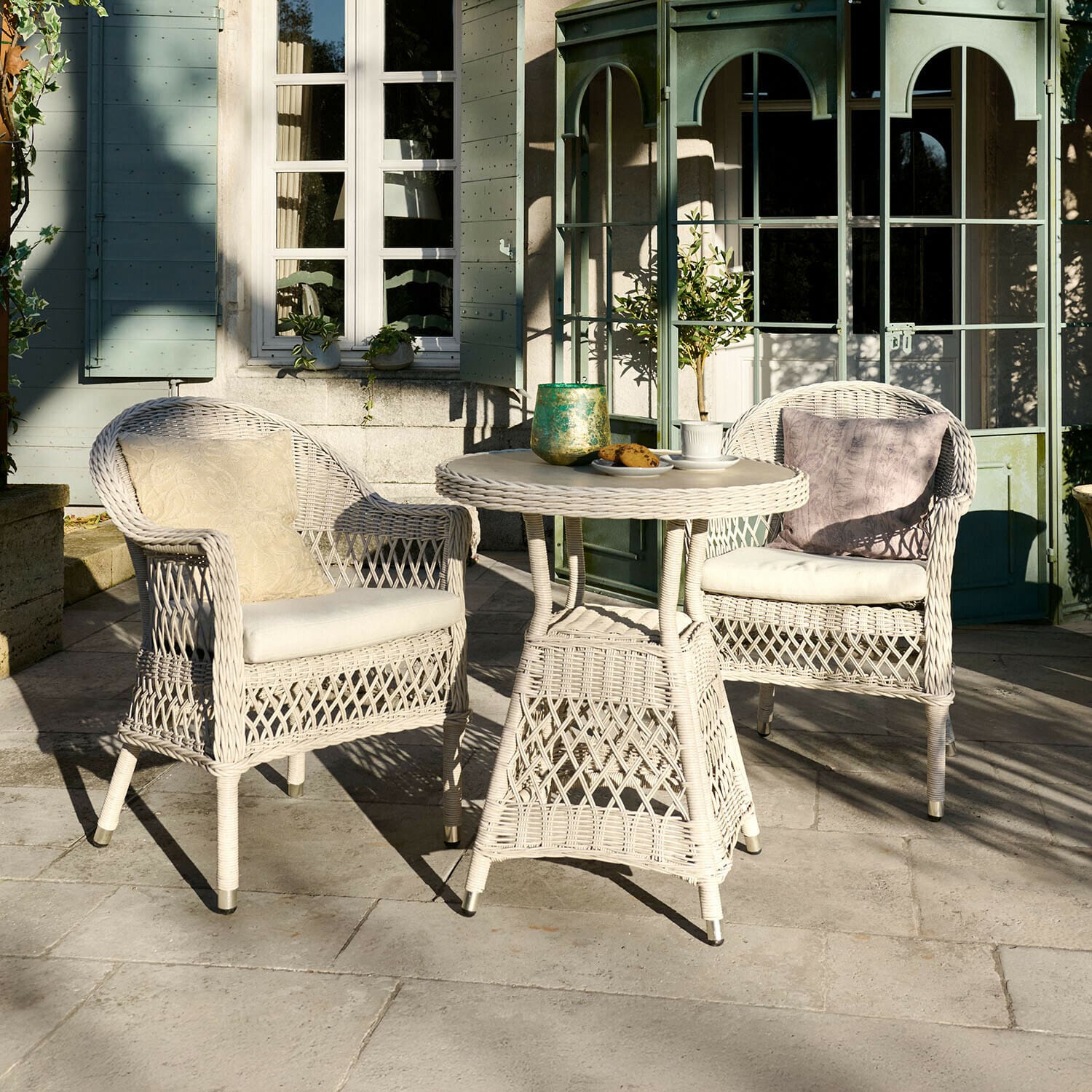 Salon de jardin Solavine Ensemble de mobilier de jardin en rotin blanc avec coussins, table ronde et deux fauteuils sur terrasse