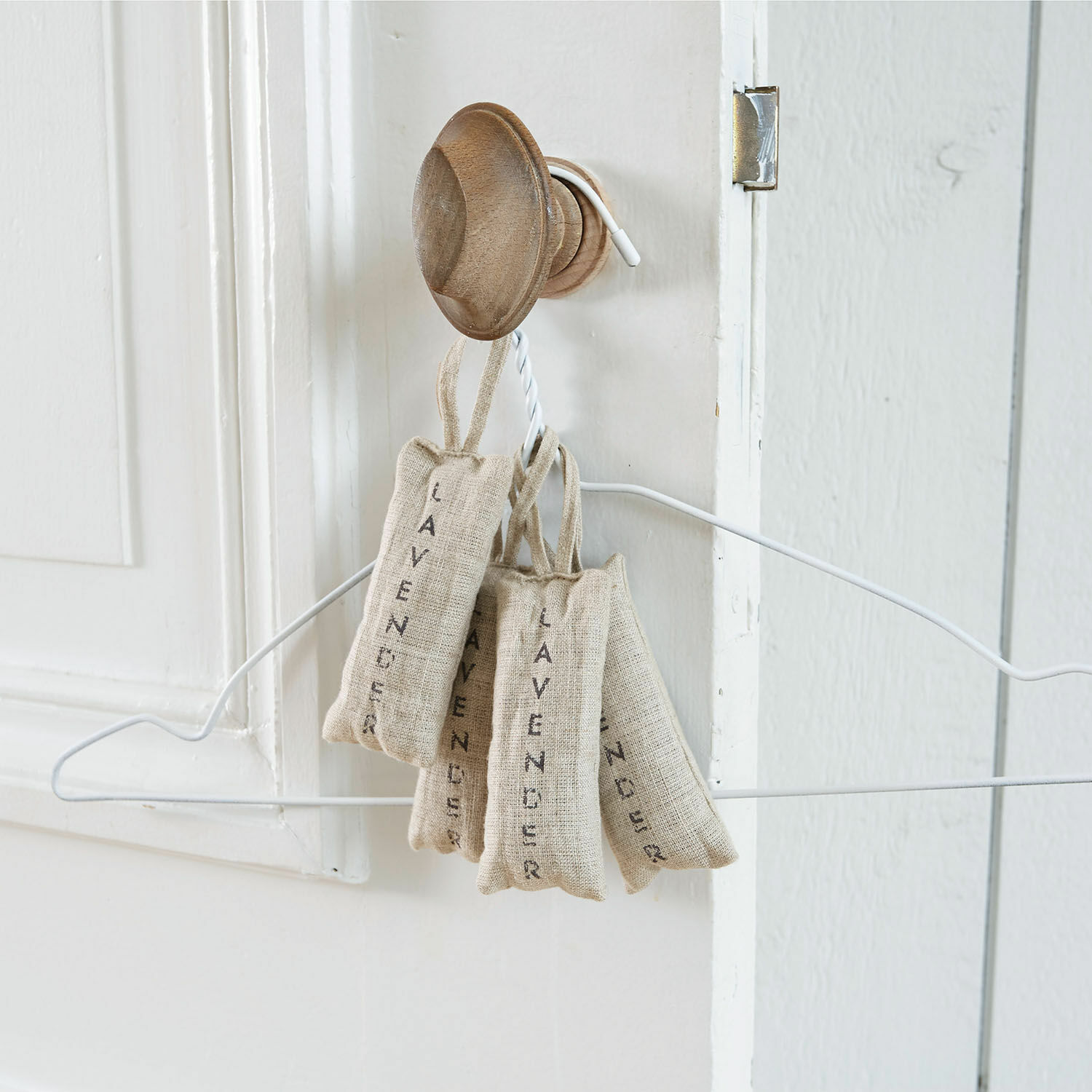 Lot de 4 pochons de lavande Boettger Sachets en lin naturel remplis de lavande suspendus à un crochet en bois sur une porte blanche
