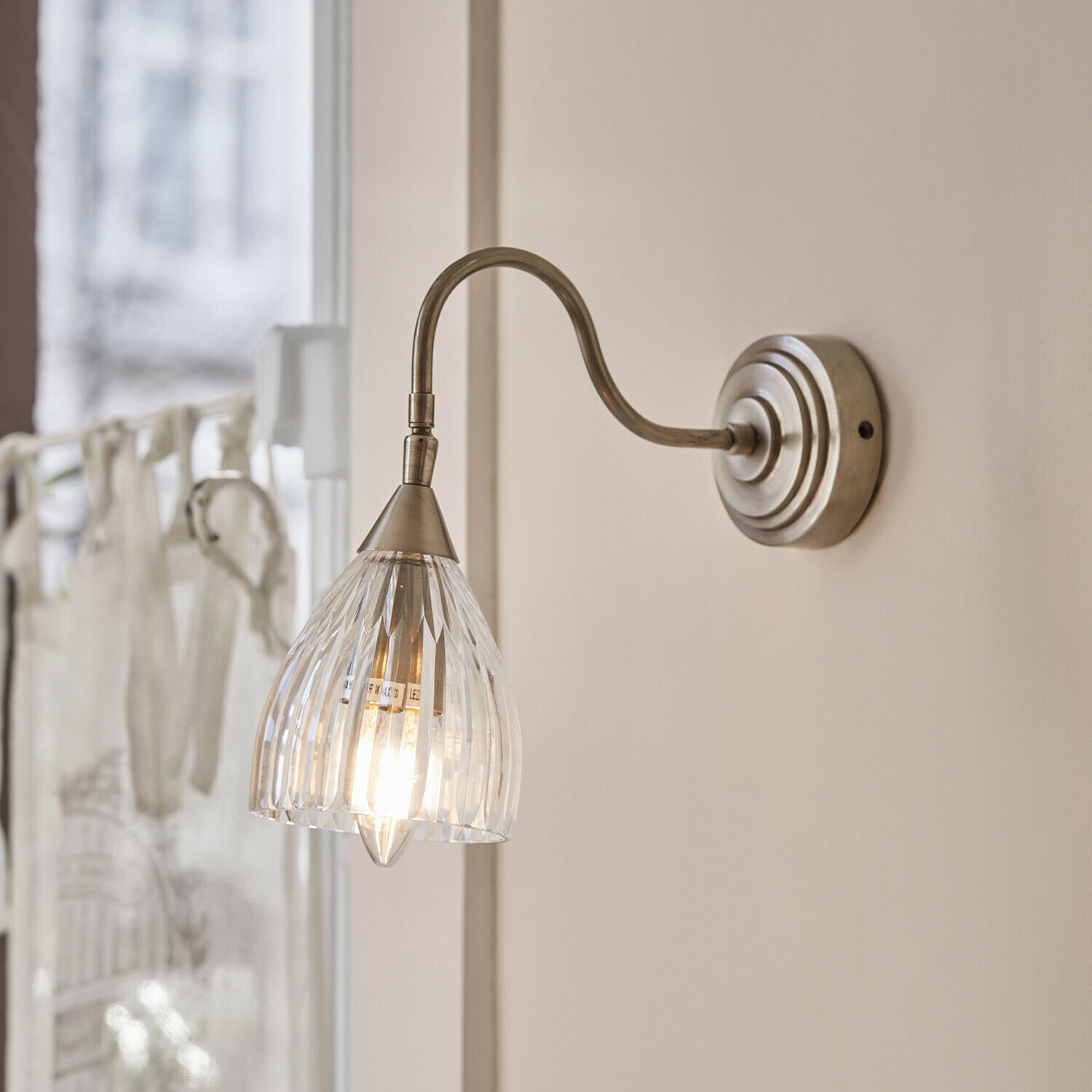 Applique Niamhs Applique murale avec abat-jour en verre transparent et bras en métal couleur argent vieilli