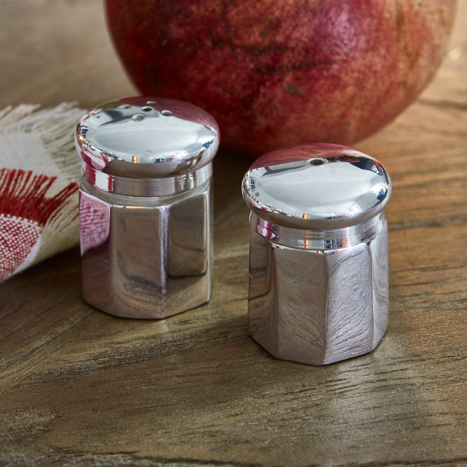 Salière et poivrière Zarenta Ensemble de salière et poivrière en métal sur table en bois avec fruit rouge en arrière-plan