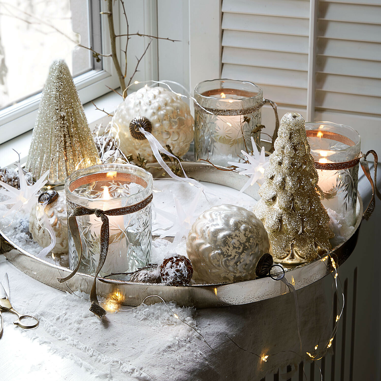 Lot de 3 photophores Selhild Plateau argenté décoratif avec ornements de Noël et bougies dans des photophores en verre sur une nappe blanche