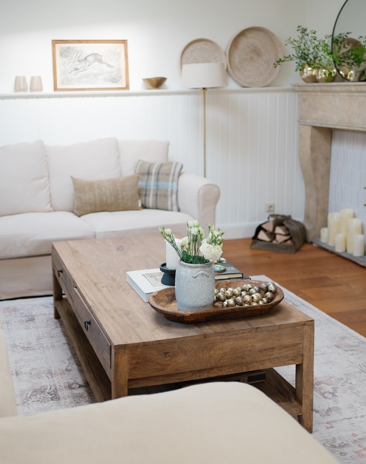 Salon avec table basse en bois et canapé beige, décorations dans un style scandinave