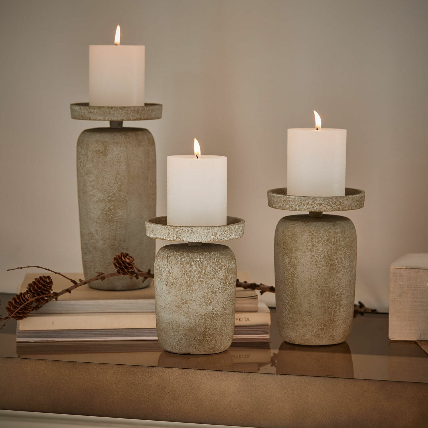 Lot de 3 bougeoirs Amsley Ensemble de trois bougeoirs en pierre beige avec bougies blanches, décoration intérieure élégante