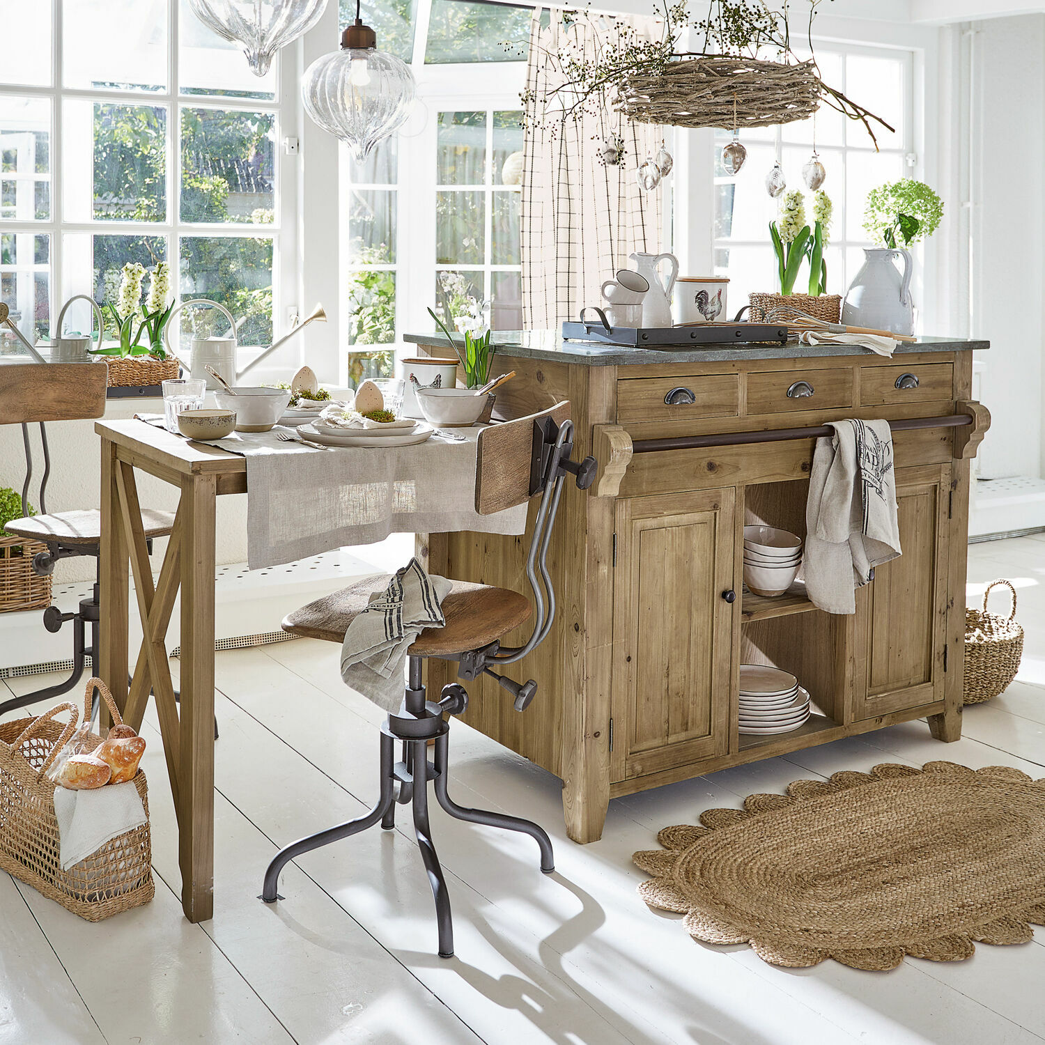 Îlot de cuisine Évain Cuisine rustique avec îlot en bois et table, matériaux naturels et décorations lumineuses dans un intérieur clair