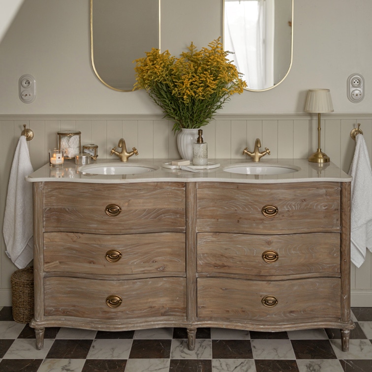 Meuble de salle de bain en bois avec plan en marbre, double vasque, robinets dorés et miroirs ovales