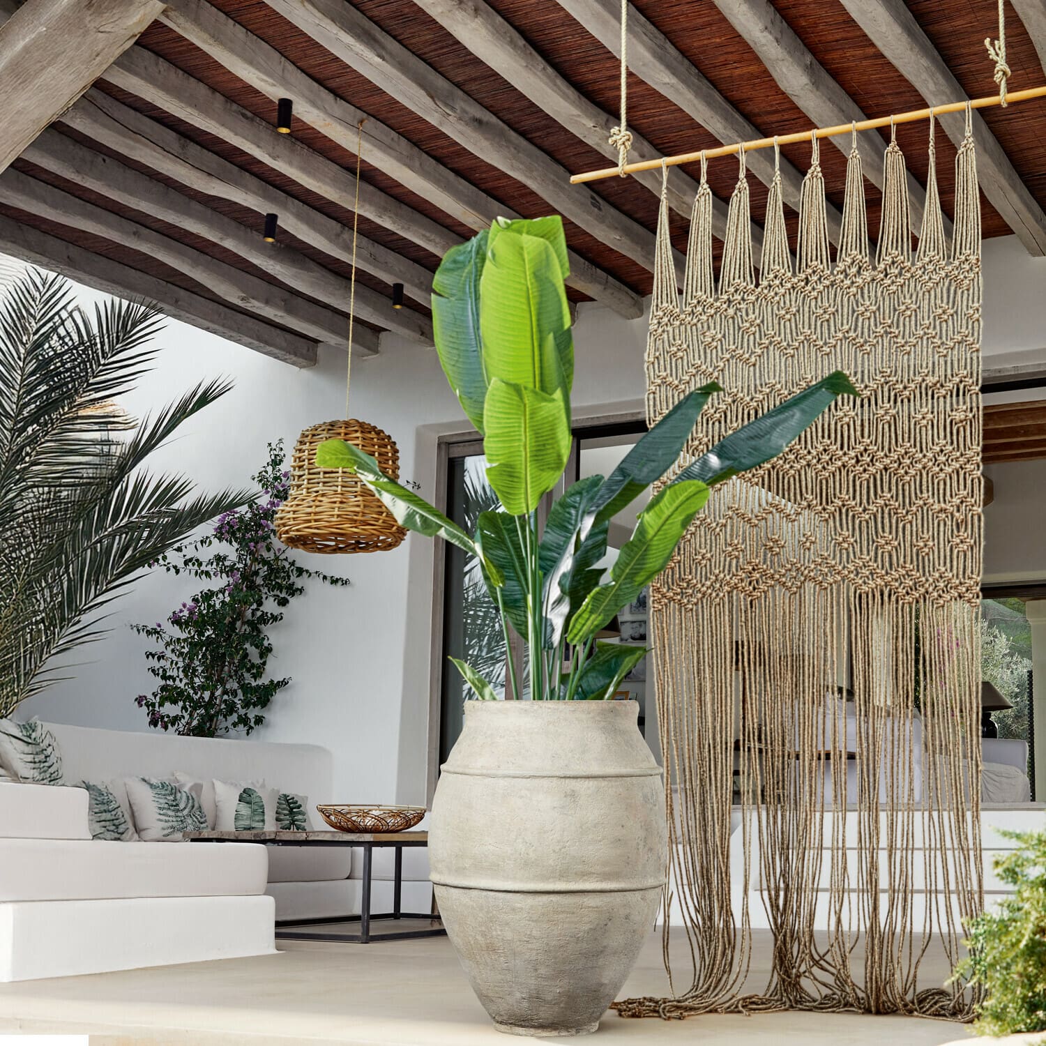 Plante décorative Lennidas Grand pot en pierre claire avec plante verte dans un salon moderne avec macramé et lampe en osier