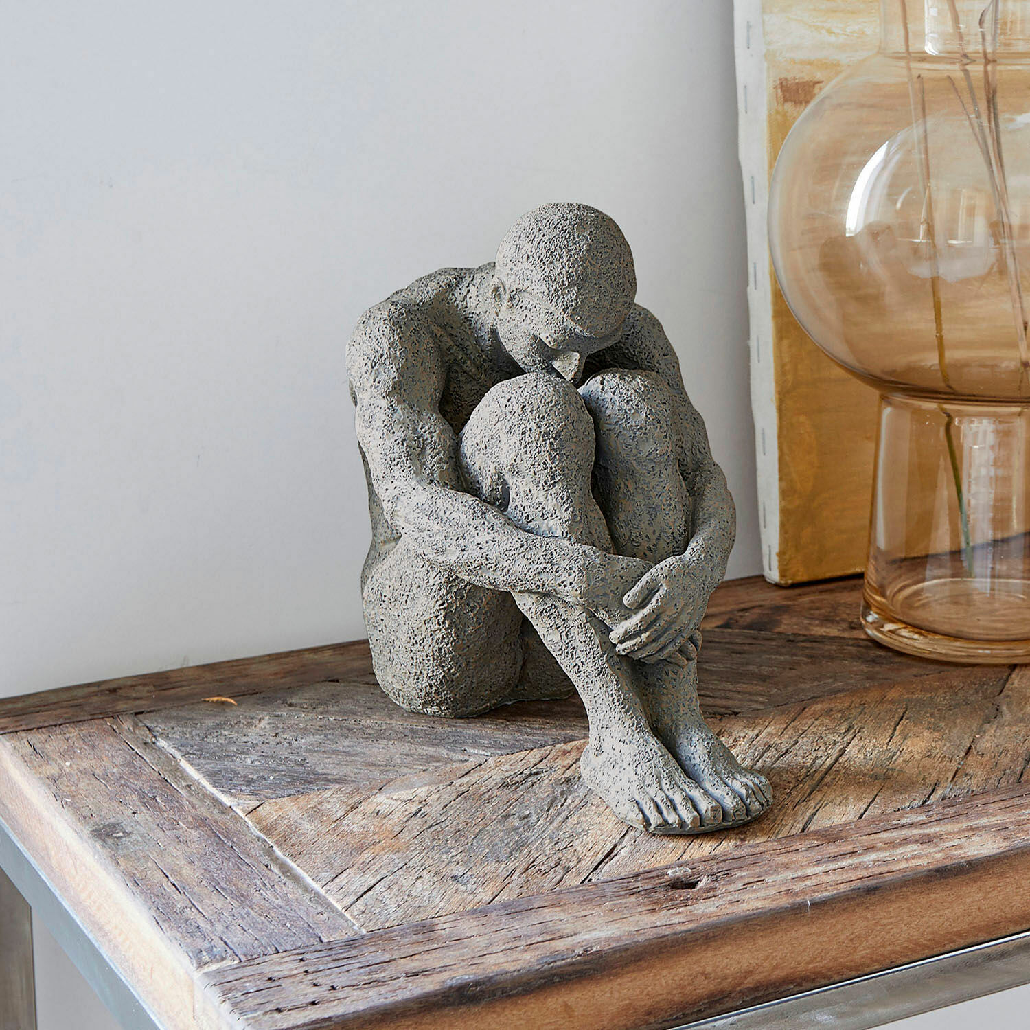 Statuette Antony Sculpture grise d'une figure assise sur une table en bois, décoration intérieure moderne