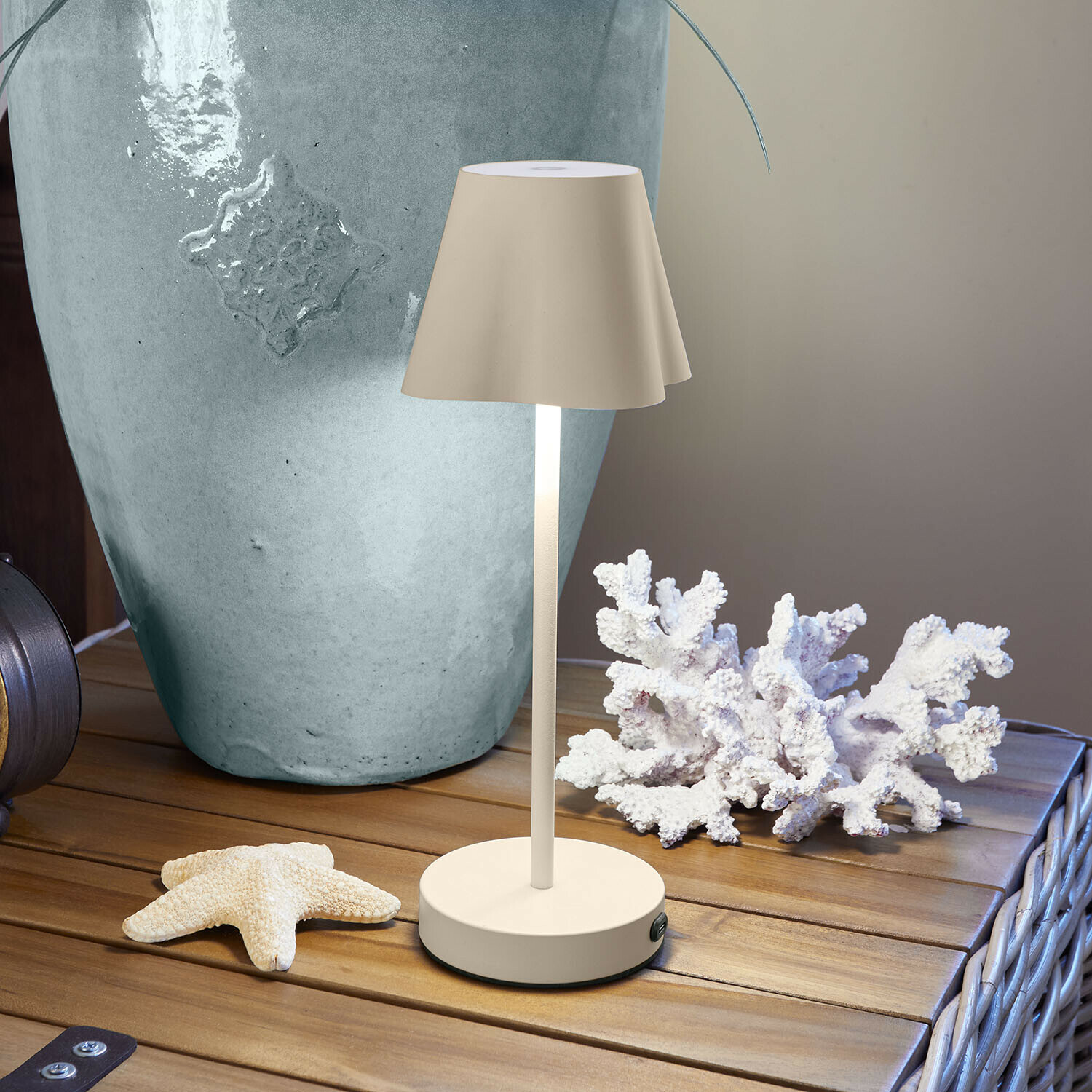 Lampe à poser rechargeable Tenari Lampe de table beige en métal sur table en bois avec décoration marine et grand vase