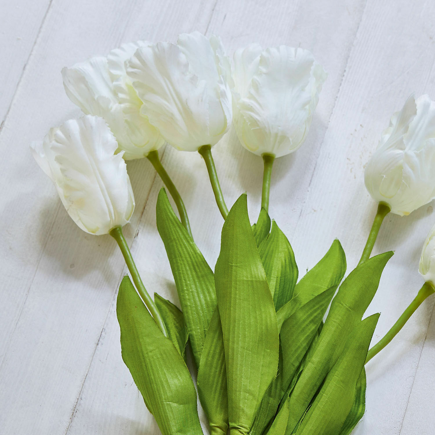 Bouquet de tulipes blanches avec feuilles vertes sur fond clair, décoration florale élégante