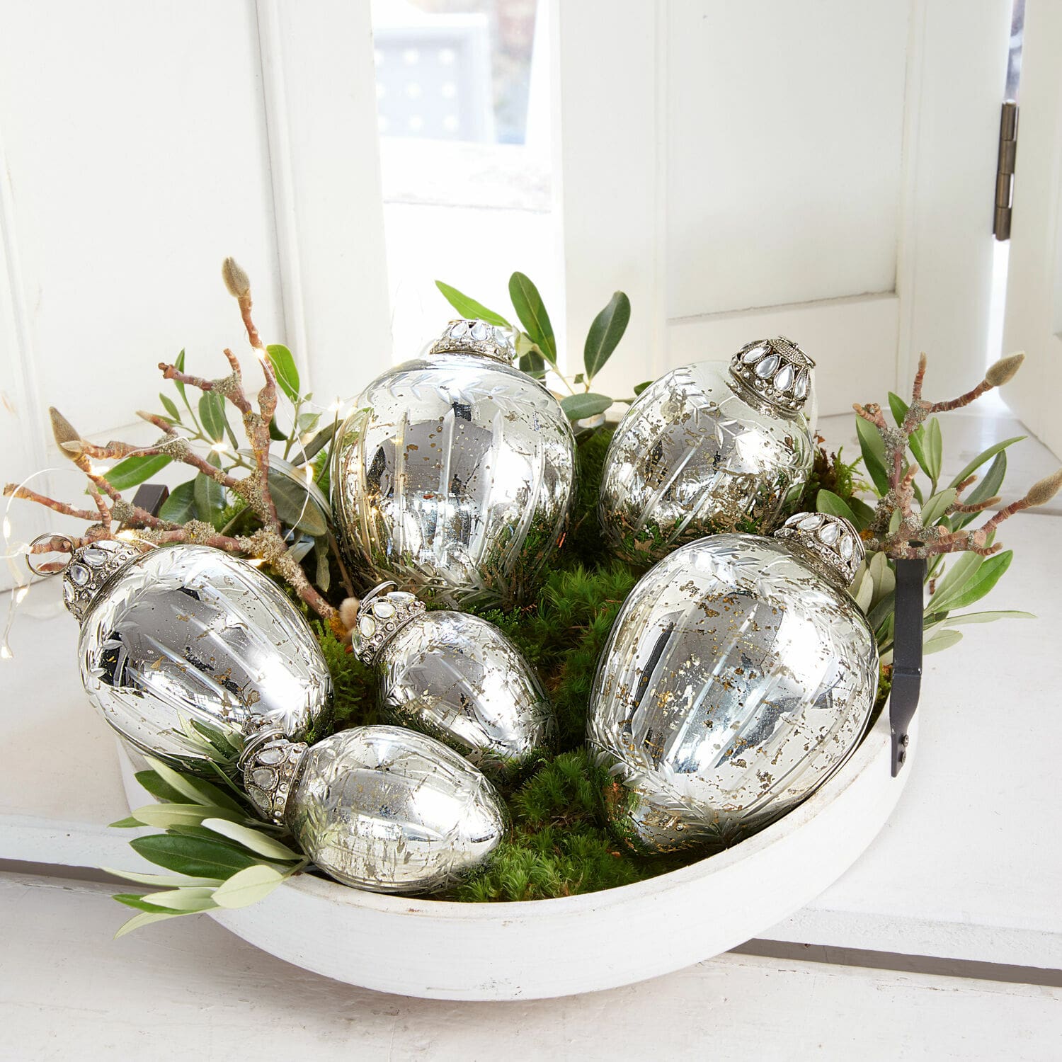 Lot de 6 œufs de Pâques Lacul Boules de Noël en verre argenté avec motifs décoratifs dans un bol blanc avec feuillage vert et mousse