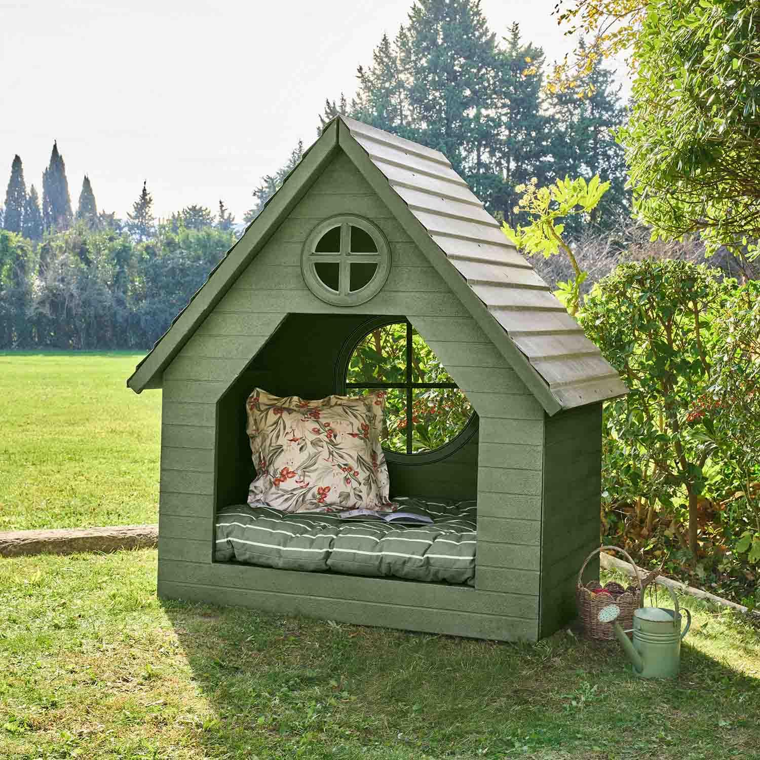 Maisonnette de jardin verte en bois avec coussin et fenêtre ronde, parfaite pour la détente extérieure