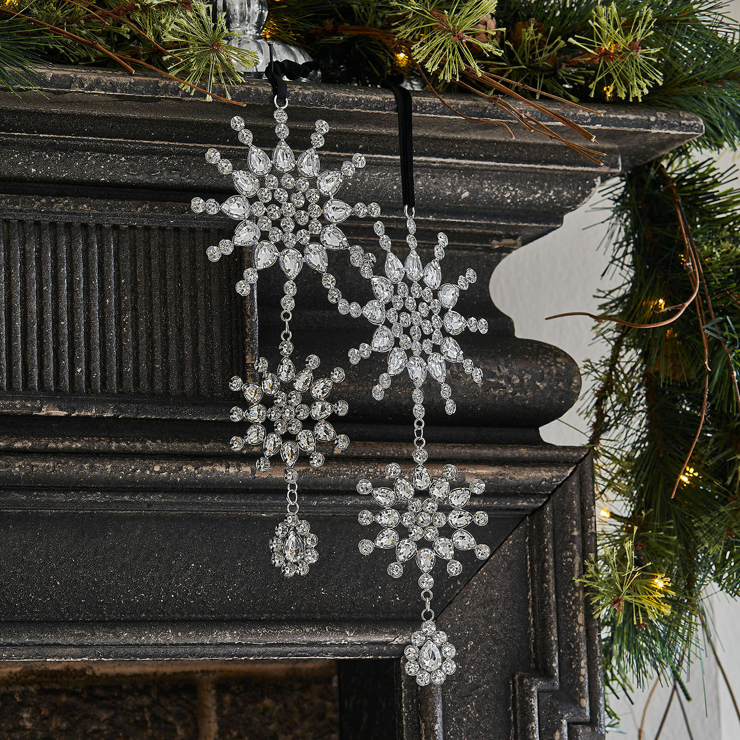 Lot de 2 décorations de Noël Klerven Décoration de Noël en cristaux transparents en forme de flocons de neige suspendue sur une cheminée noire avec des branches vertes
