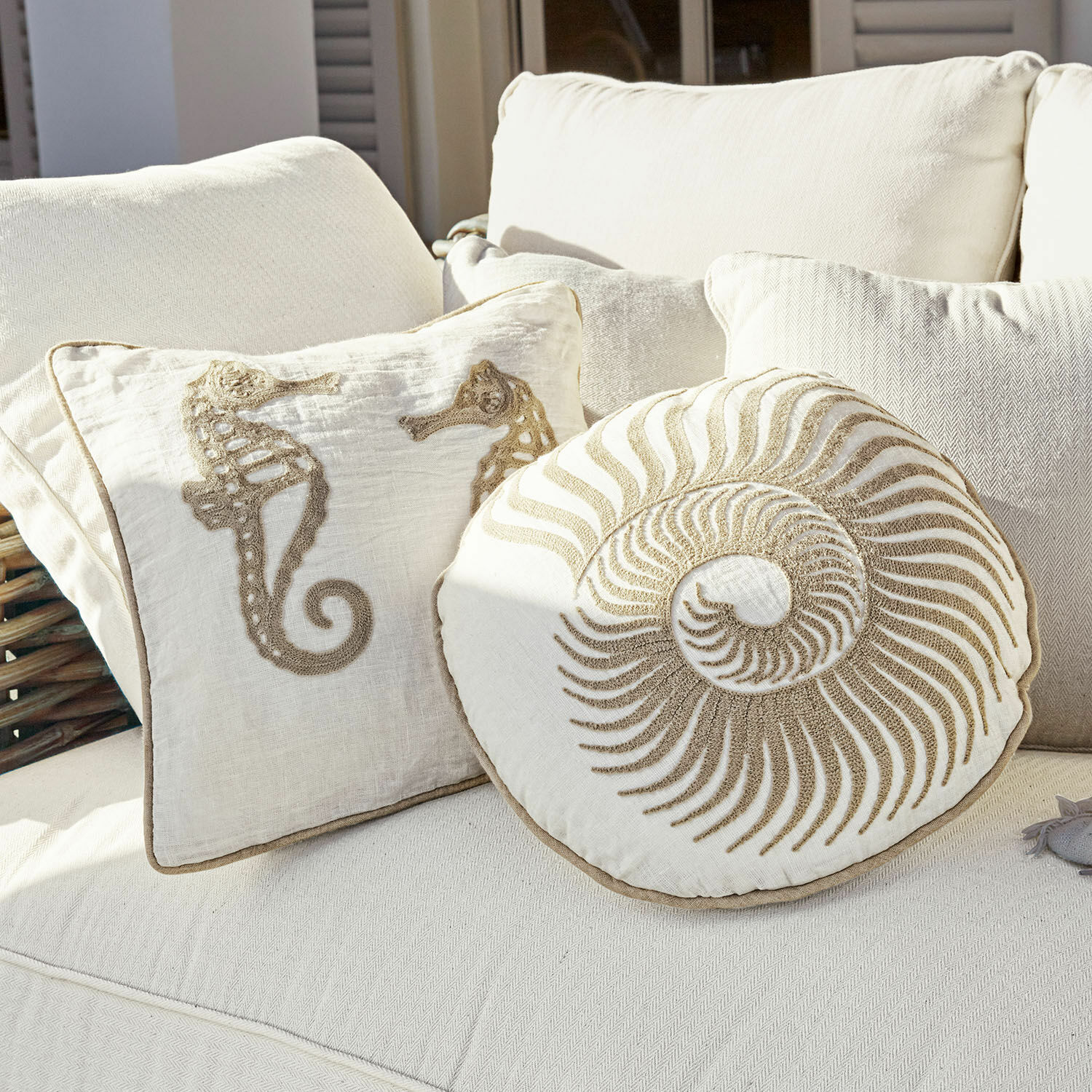 Lot de 2 coussins Bristol Coussins décoratifs en coton crème avec motifs hippocampes et coquillage sur canapé clair