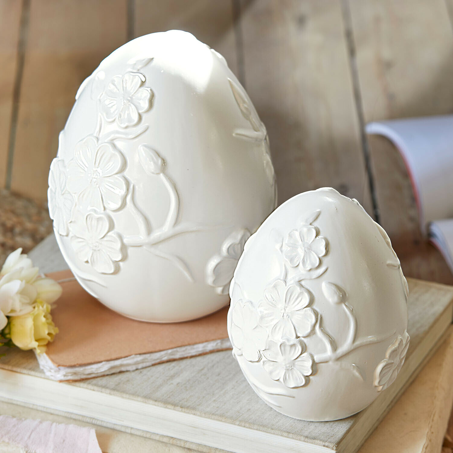Lot de 2 œufs de Pâques Vent Élysien Œufs décoratifs en céramique blanche avec motifs floraux en relief posés sur des livres