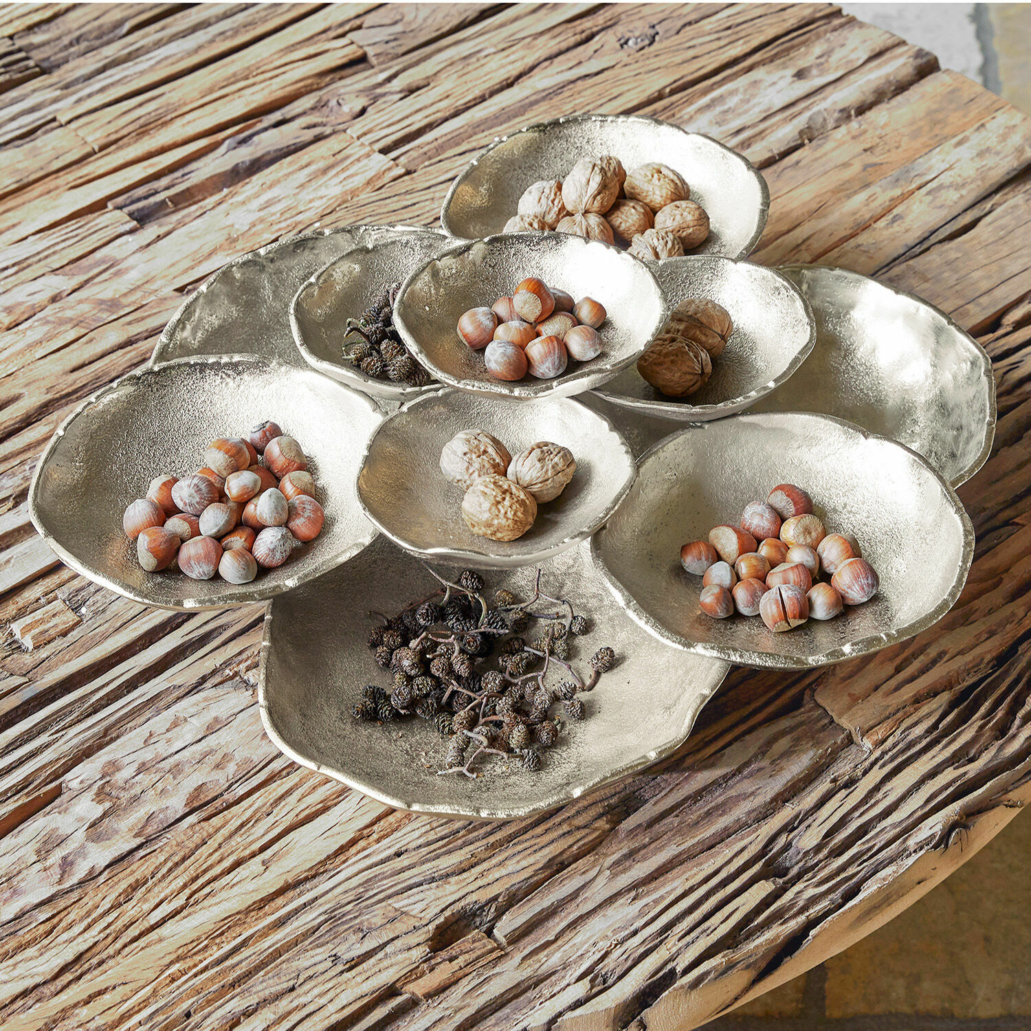 Coupe Gibril Plat décoratif en métal argenté avec noix et fruits secs sur une table en bois rustique