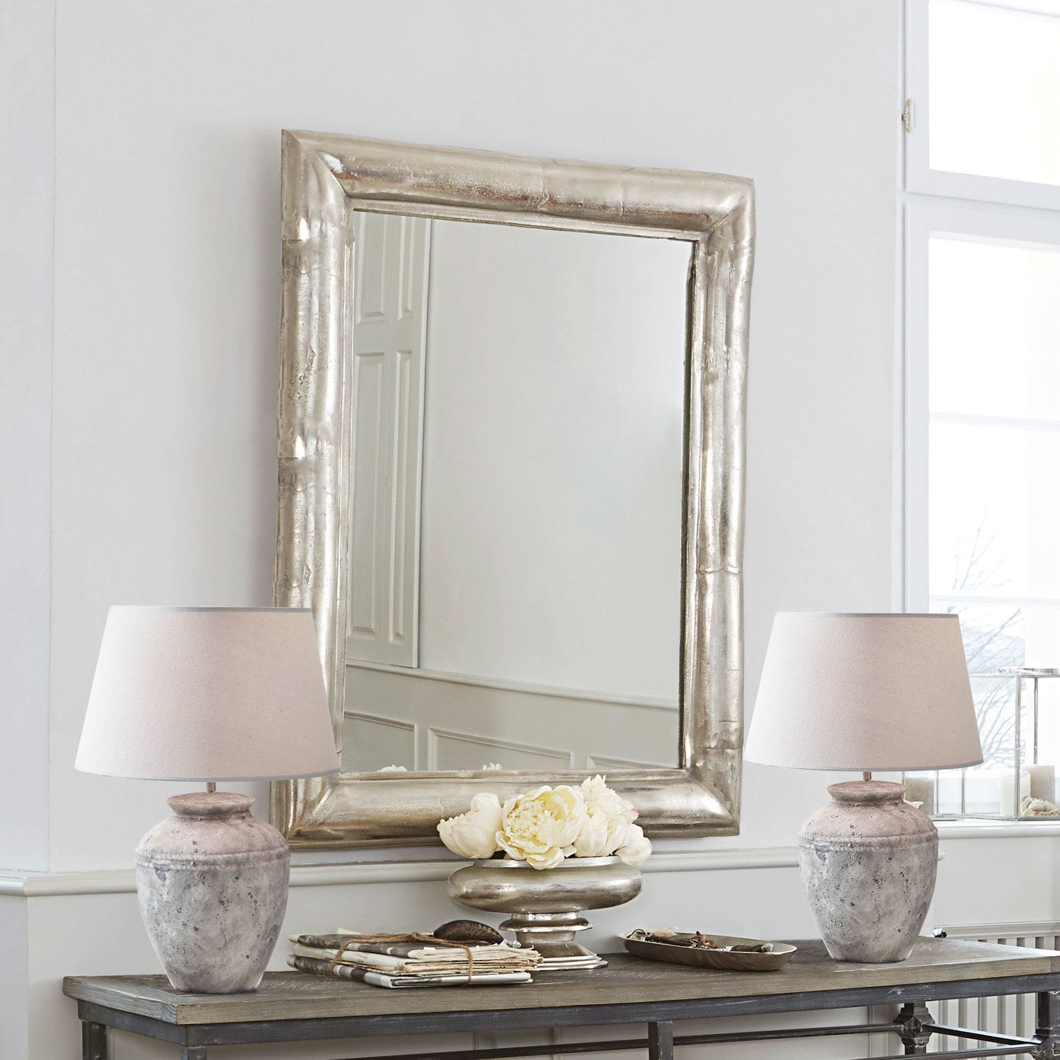 Miroir Richland Grand miroir rectangulaire avec cadre métallique argenté au-dessus d'une table en bois avec lampes en pierre