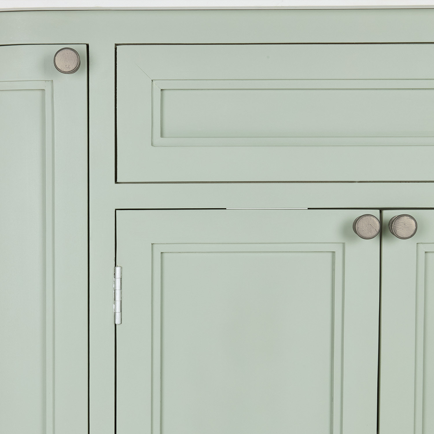 Façade d'armoire vert pastel avec poignées en bois et panneaux classiques pour rangement