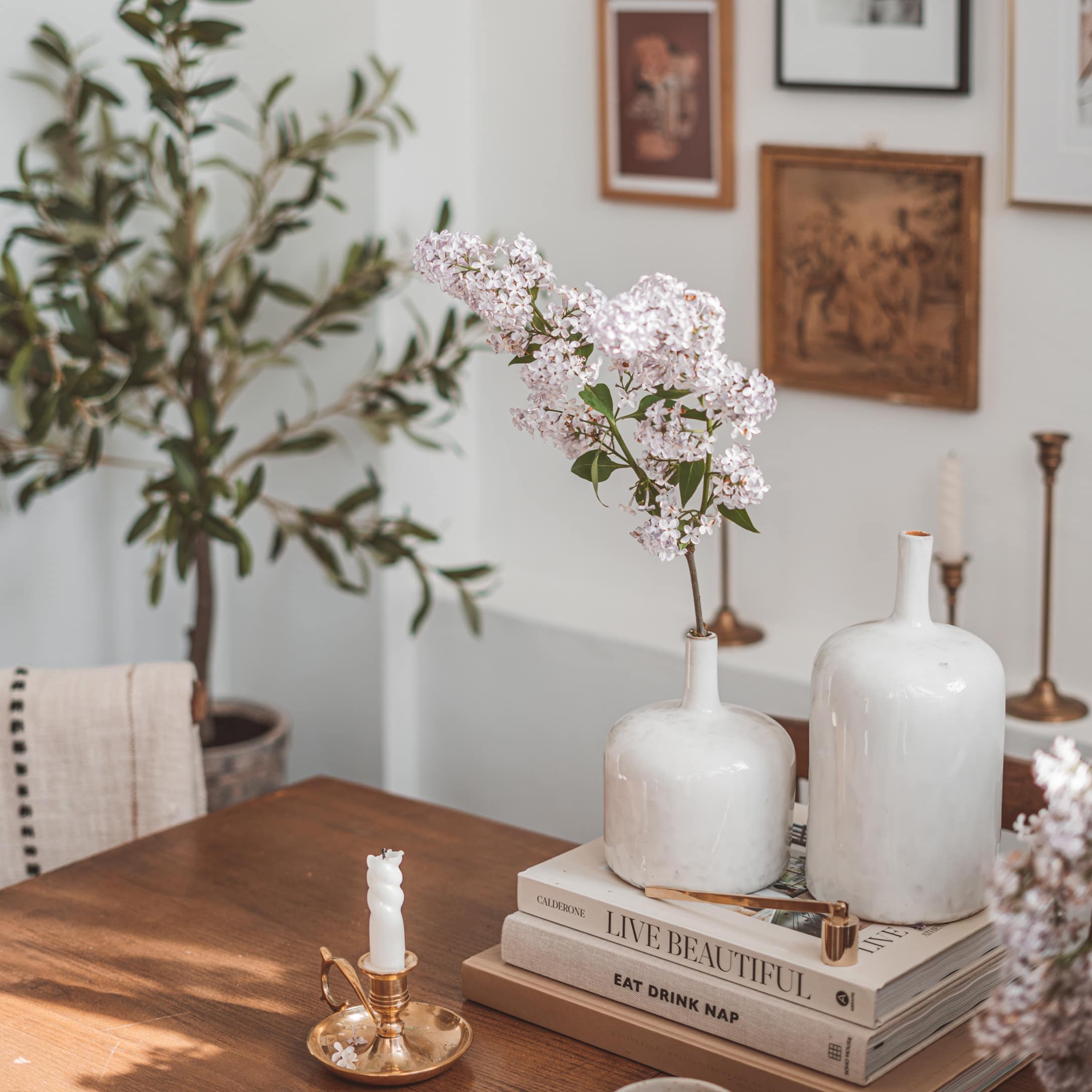 Vases en céramique blanche sur table en bois avec fleurs et bougeoir doré vintage