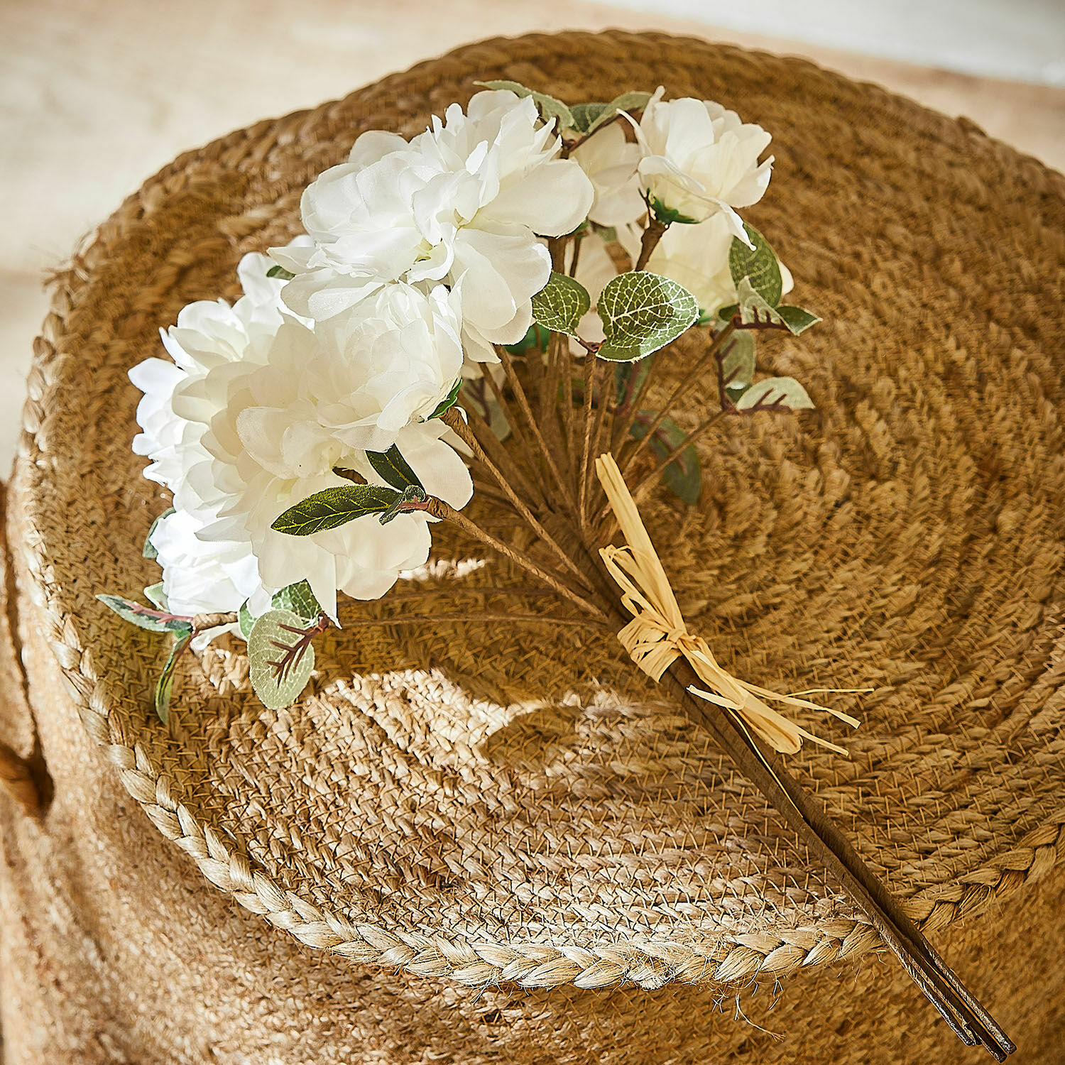 Bouquet décoratif Quérisse Bouquet de fleurs artificielles blanches avec feuilles vertes sur fond tressé naturel en jute