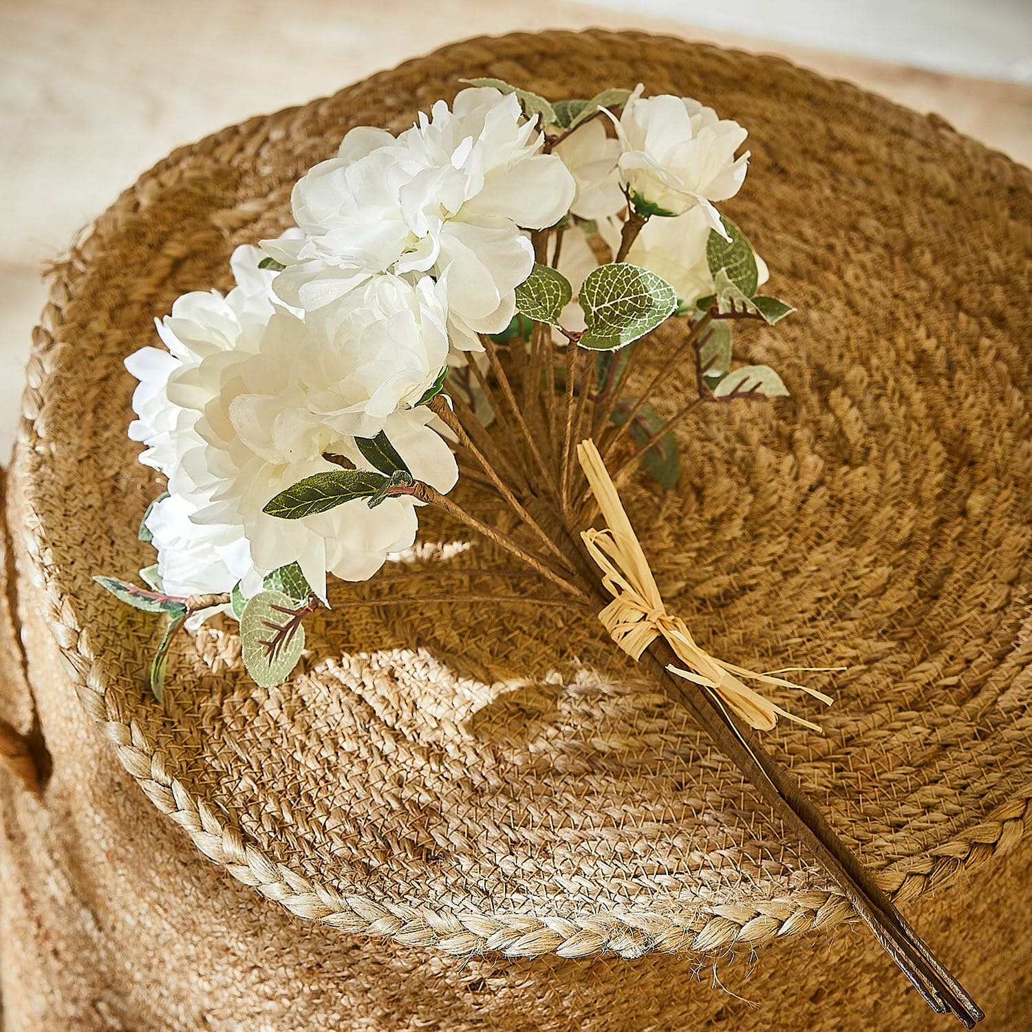 Bouquet décoratif Quérisse Bouquet de fleurs artificielles blanches avec feuilles vertes sur fond tressé naturel en jute