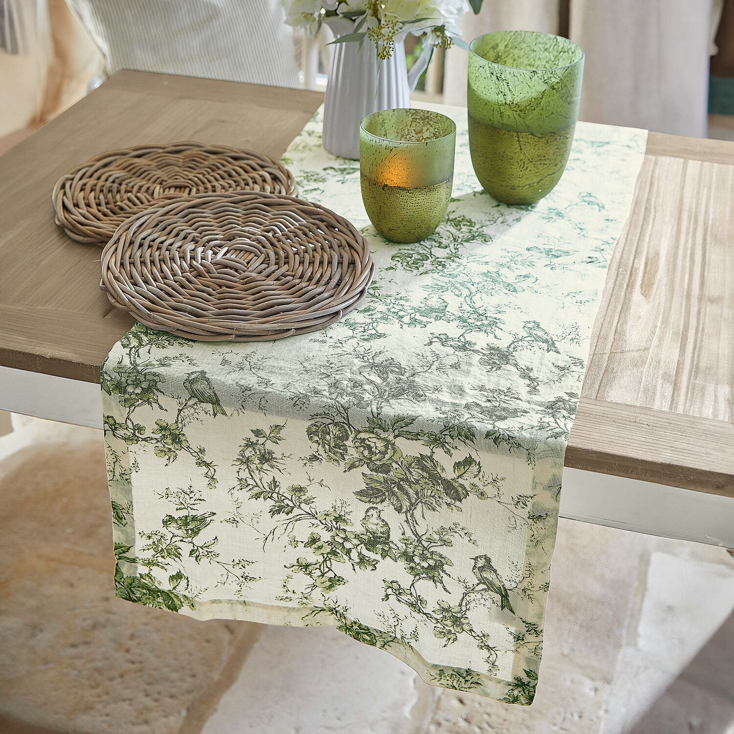 Chemin de table Mercier Chemin de table en lin à motif végétal vert sur table en bois avec dessous de verre en osier et verres verts