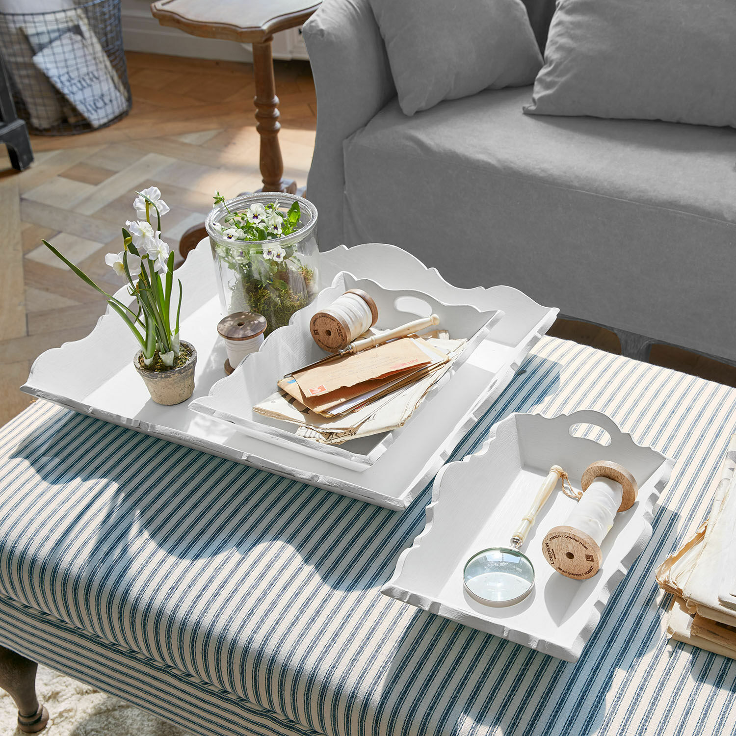 Lot de 3 plateaux Pirelo Plateaux décoratifs en bois blanc sur un tissu rayé avec plantes et accessoires d'écriture