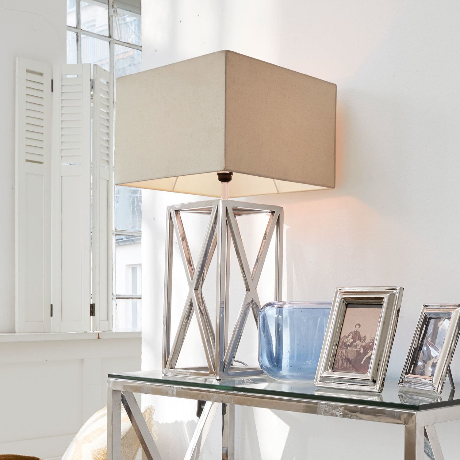 Lampe à poser Foix Lampe de table moderne avec base en métal et abat-jour beige sur une table en verre dans un intérieur lumineux
