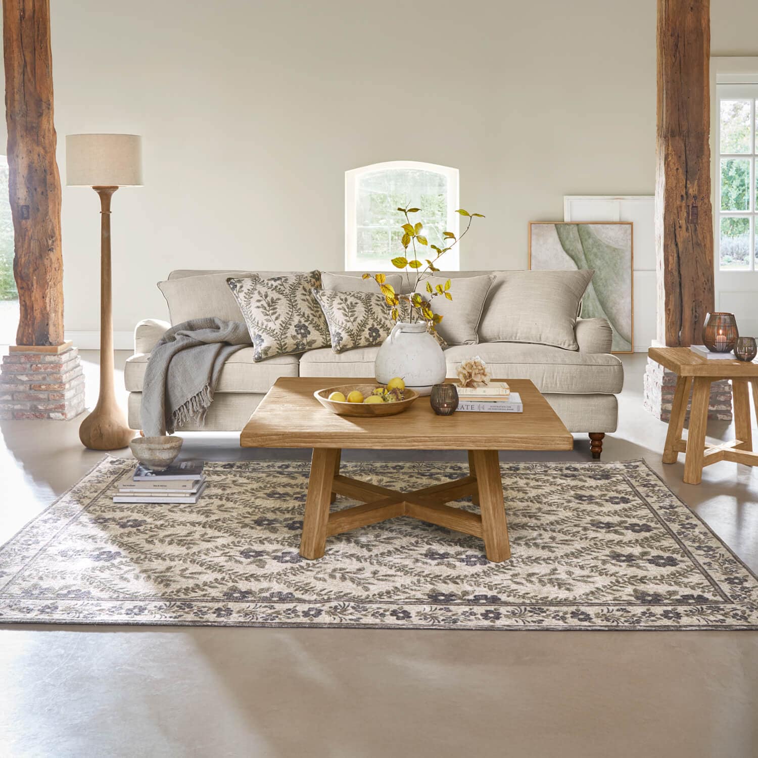 Salon chaleureux avec canapé beige, table basse en bois et tapis à motif floral
