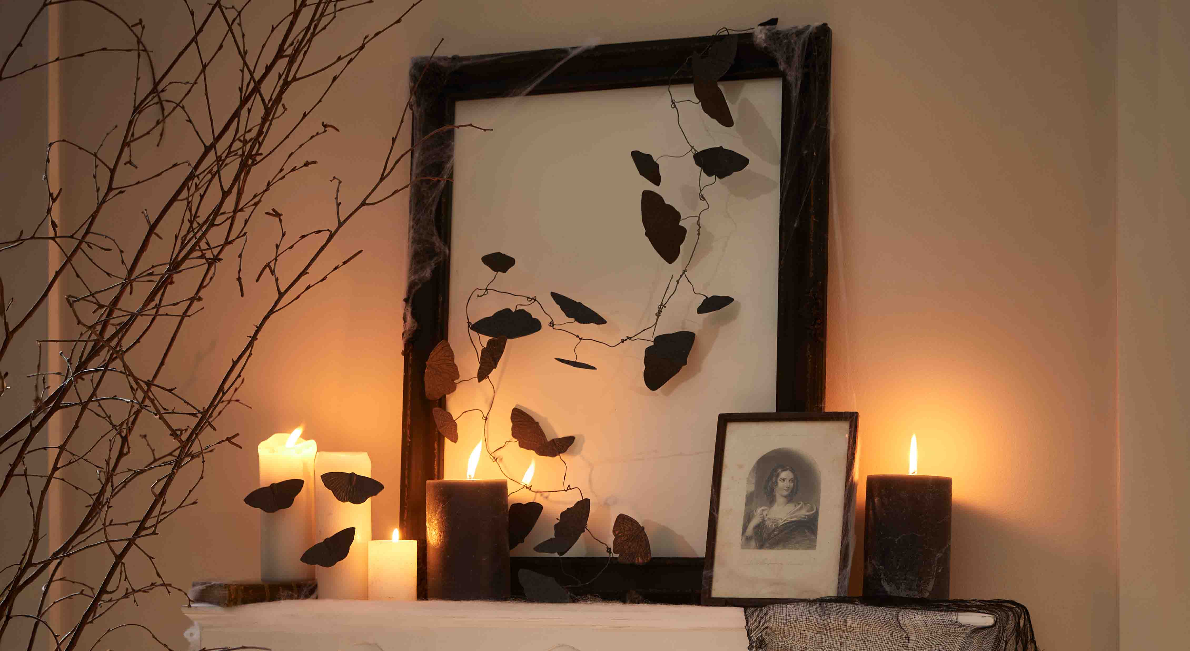 Bougies noires et blanches avec décorations papillons en fil métallique sur cadre, ambiance chaleureuse