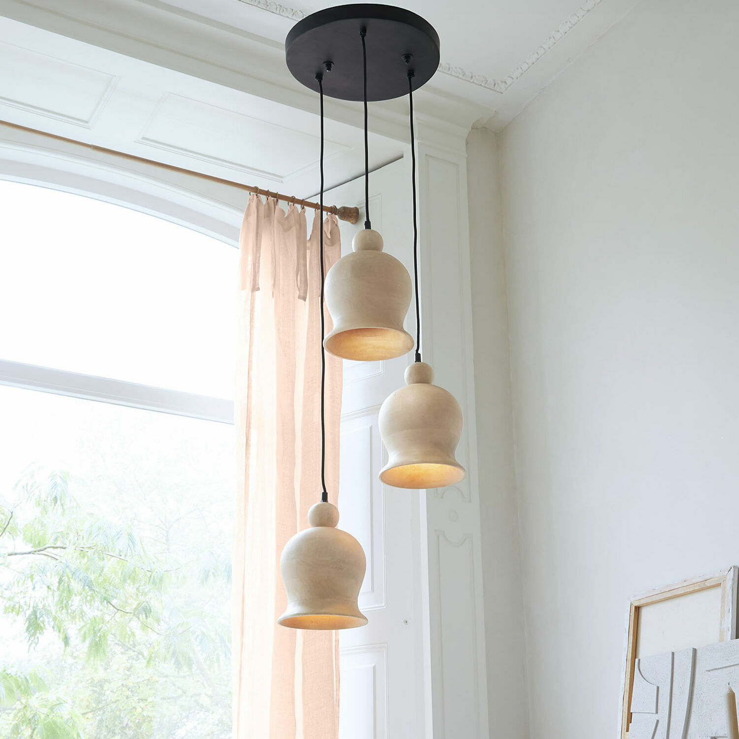 Suspension Ziravet Trois suspensions en bois clair au design organique dans une pièce lumineuse avec grande fenêtre