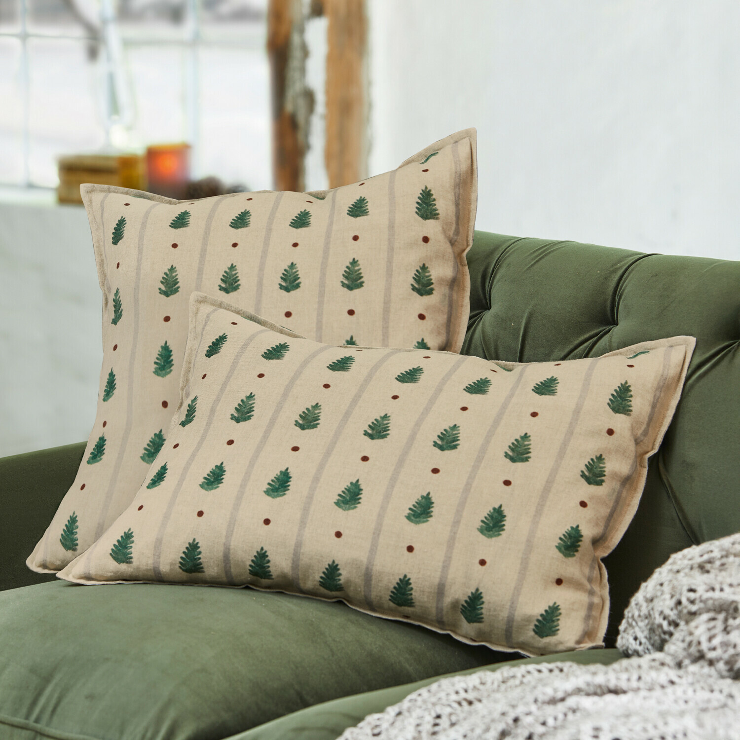 Lot de 2 housses de coussins Emily Coussins beiges à motif feuilles vertes sur canapé vert, décoration textile pour salon