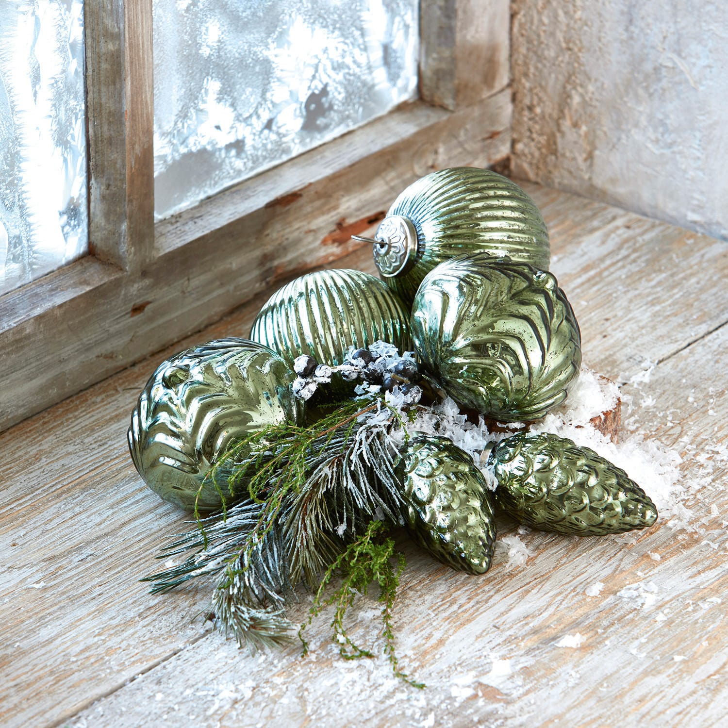 Lot de 6 décorations de Noël Silverhill Boules de Noël vertes en verre avec différentes textures, branches et fausse neige sur un rebord en bois