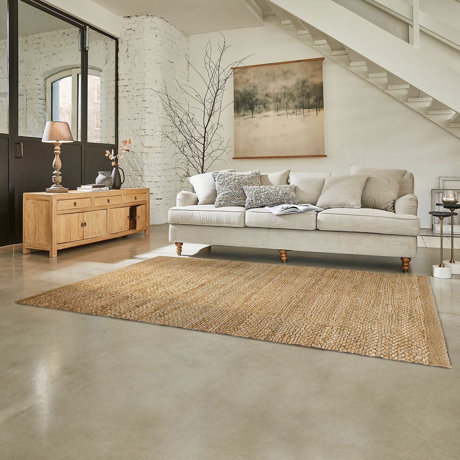 Tapis Abitain Canapé beige avec coussins et buffet en bois clair dans un salon lumineux avec tapis en jute naturel