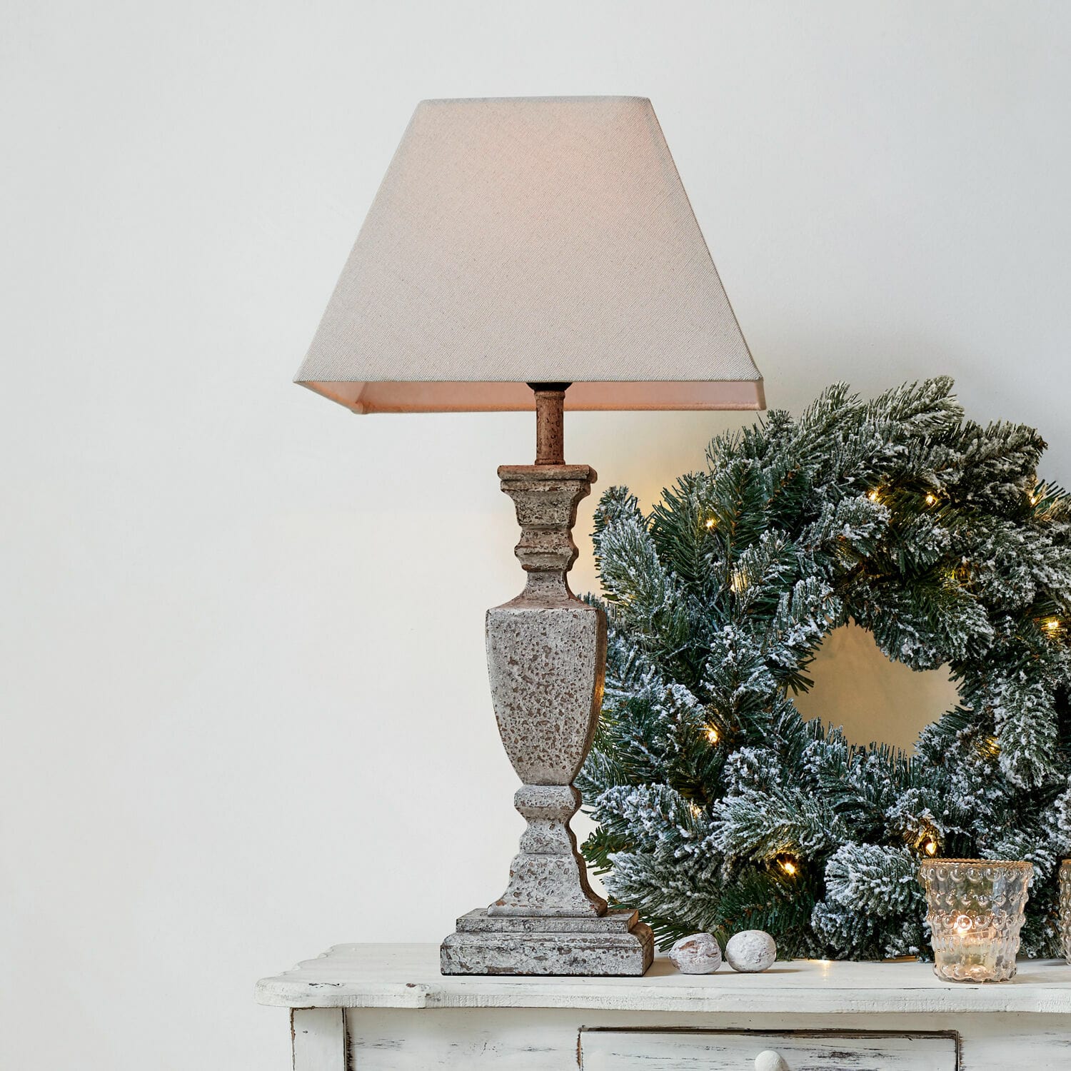 Lampe à poser Gorham Lampe de table en pierre beige avec abat-jour à côté d'une couronne de Noël verte décorée de lumières