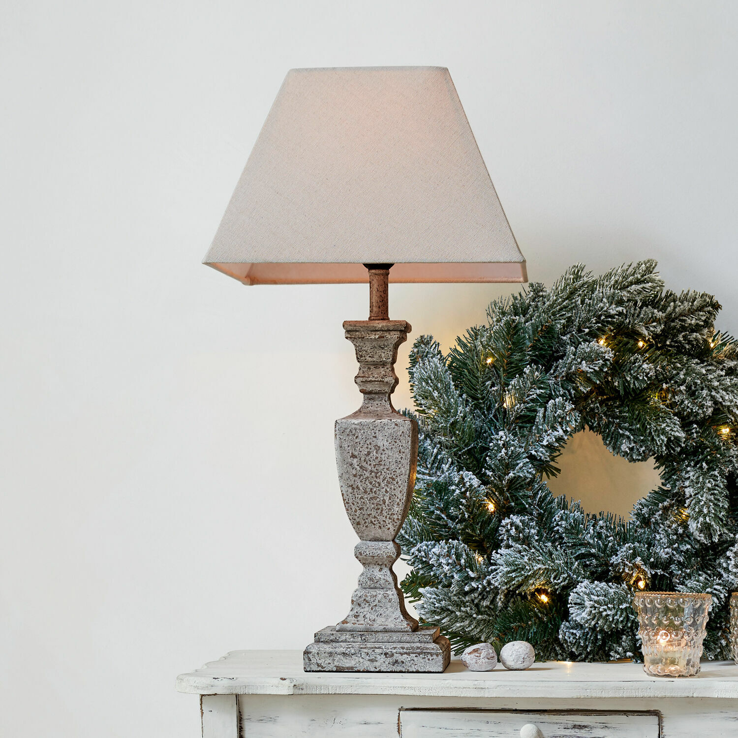 Lampe à poser Gorham Lampe de table en pierre beige avec abat-jour à côté d'une couronne de Noël verte décorée de lumières
