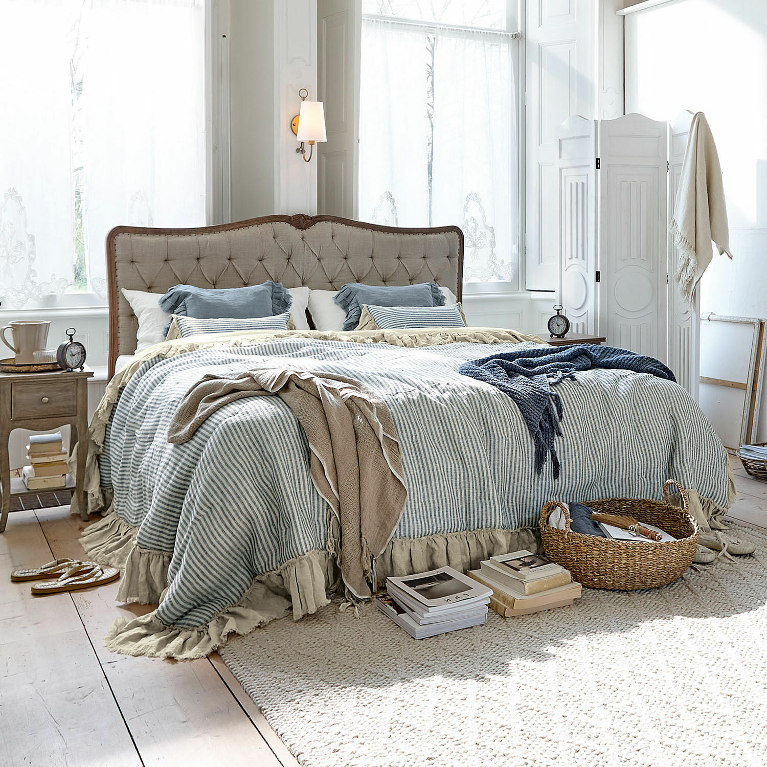 Courtepointe Alexane Chambre chaleureuse avec lit en tissu beige et linge de lit rayé bleu et blanc
