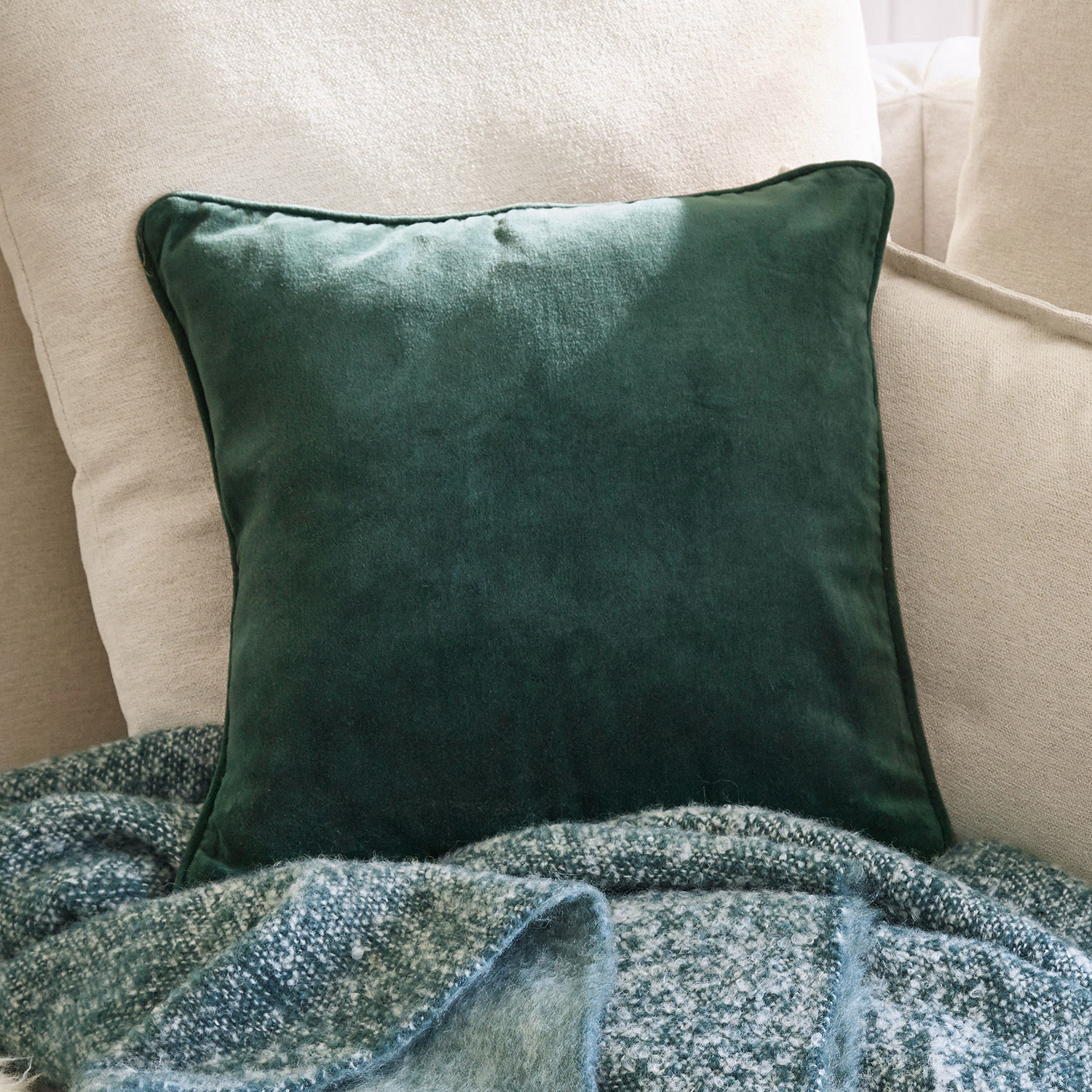 Housse de coussin Gany Coussin décoratif vert en velours sur un canapé beige avec une couverture douce en arrière-plan