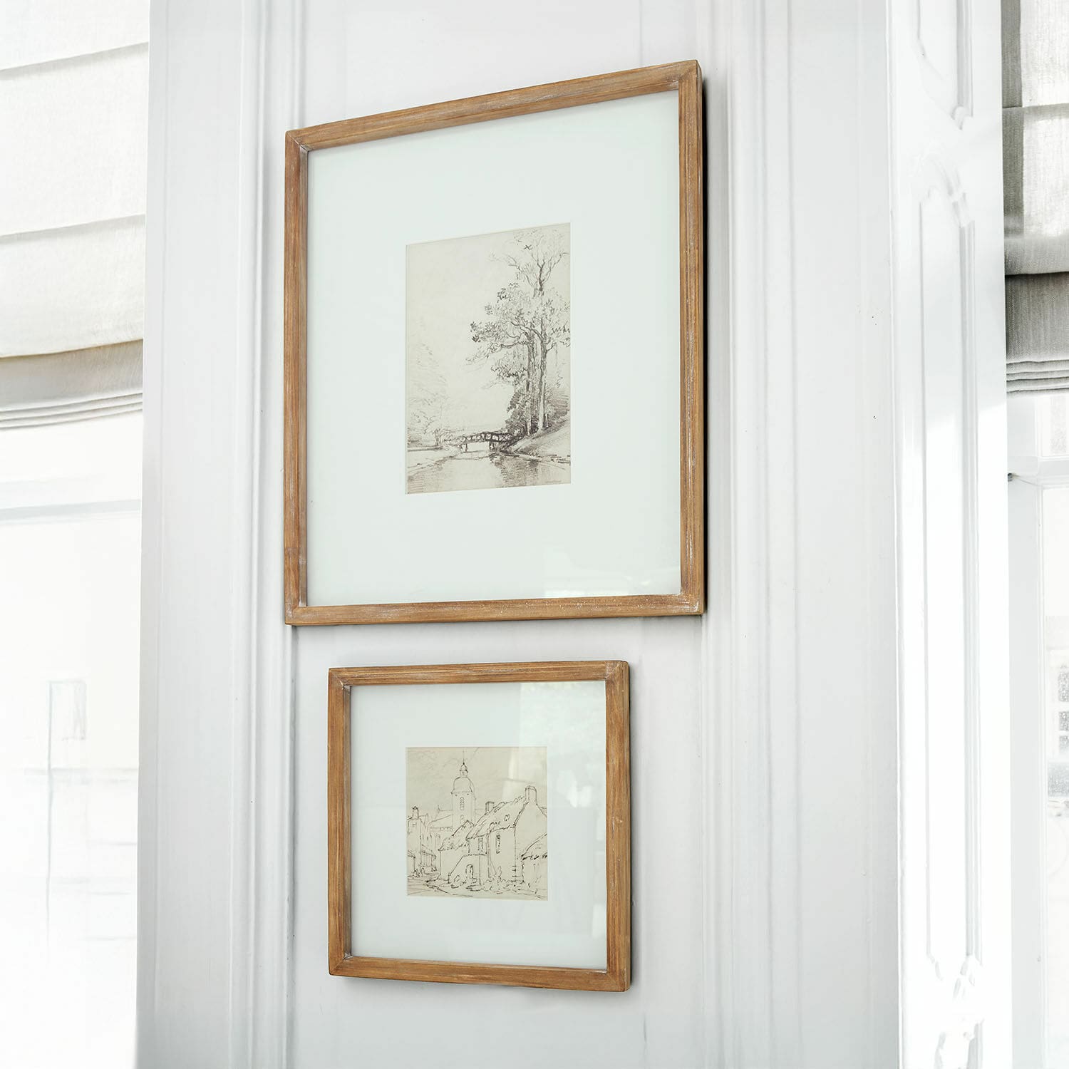 Lot de 2 tableaux Juvarel Deux cadres en bois rustique avec dessins de paysages accrochés sur un mur blanc lumineux