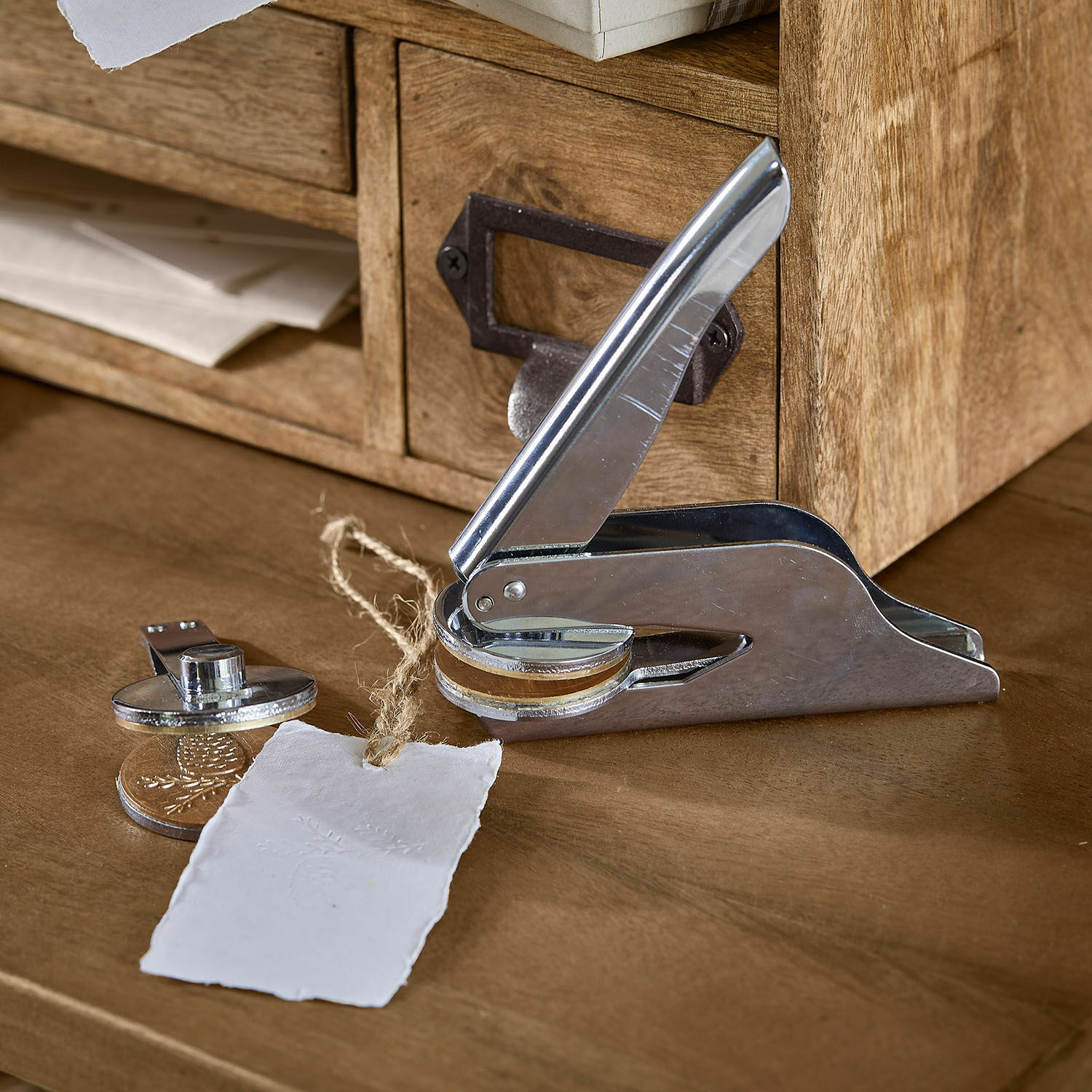 Pince à gaufrer Prenisto Presse à papier en métal avec élément en bois sur bureau en bois avec étiquette en papier