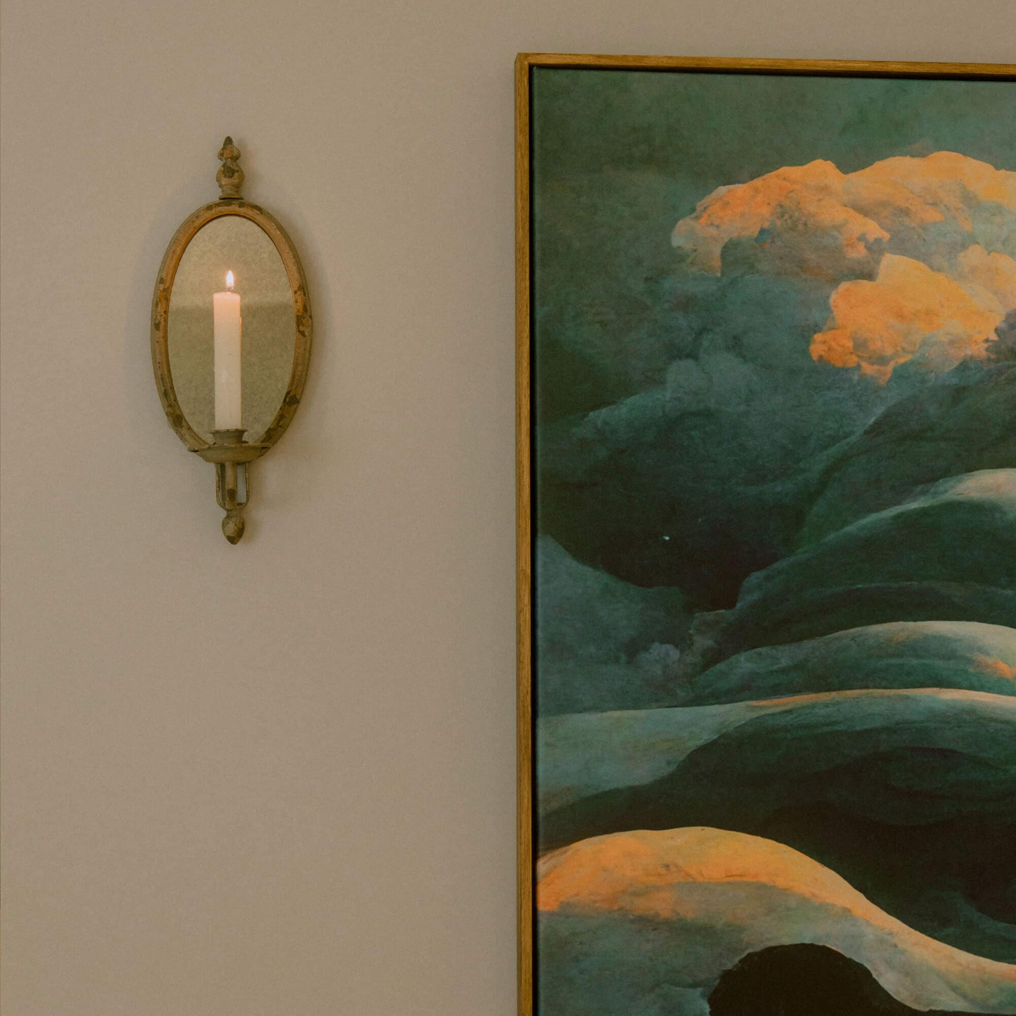 Applique murale ovale en métal avec miroir et bougie blanche sur mur beige pour décoration intérieure