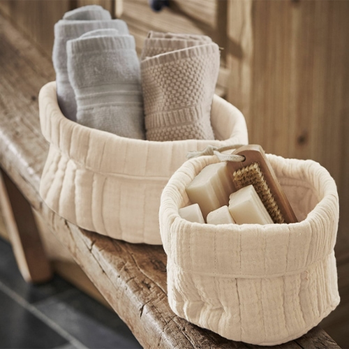 Deux paniers en tissu crème avec serviettes et savon, accessoires de salle de bain naturels