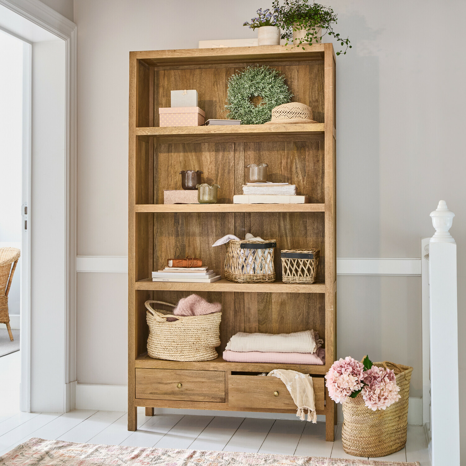Étagère Dalesford Étagère en bois avec quatre niveaux et deux tiroirs, décorée de paniers et textiles aux tons clairs