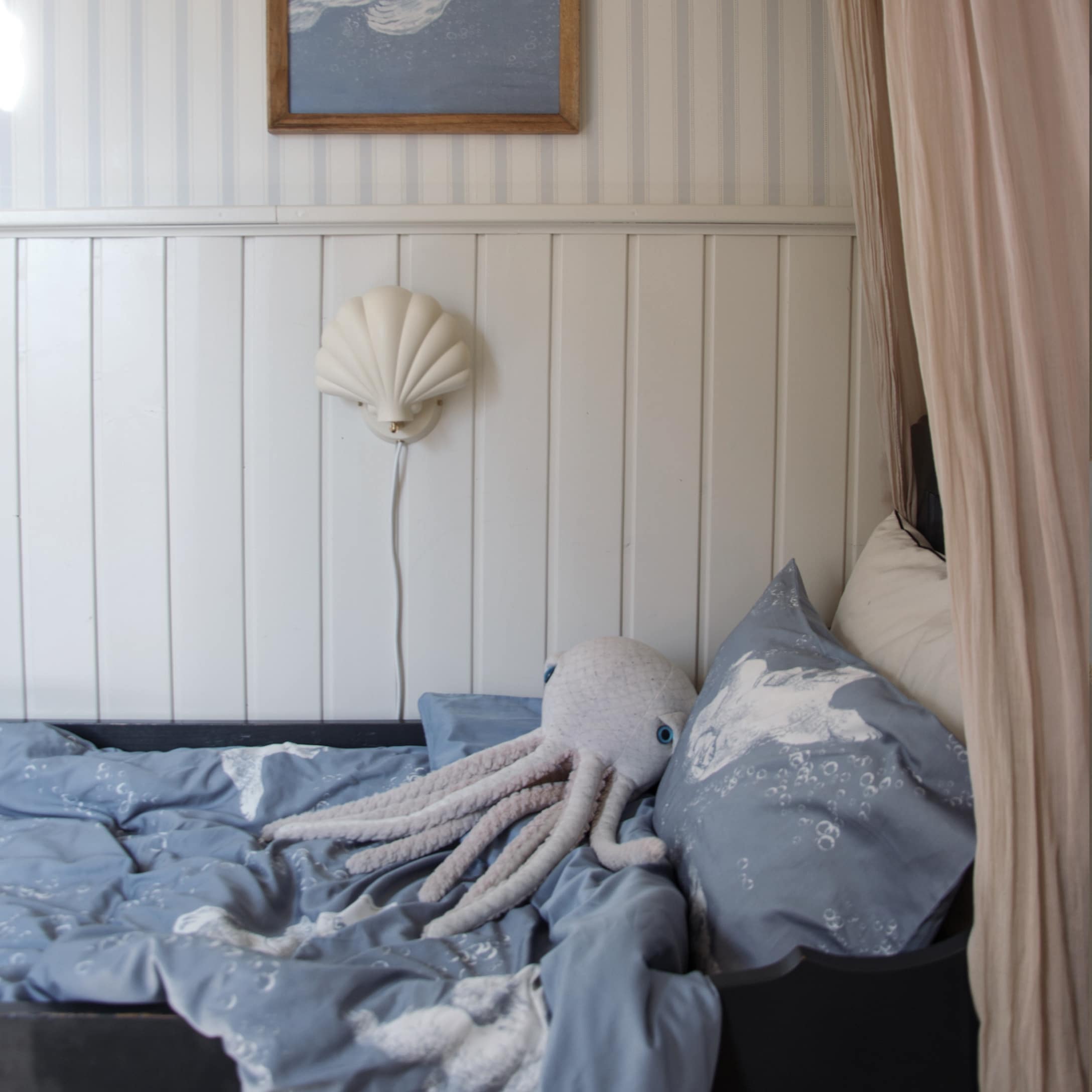 Linge de lit bleu pour enfant avec motif pieuvre et peluche pieuvre sur un lit dans une chambre d'enfant