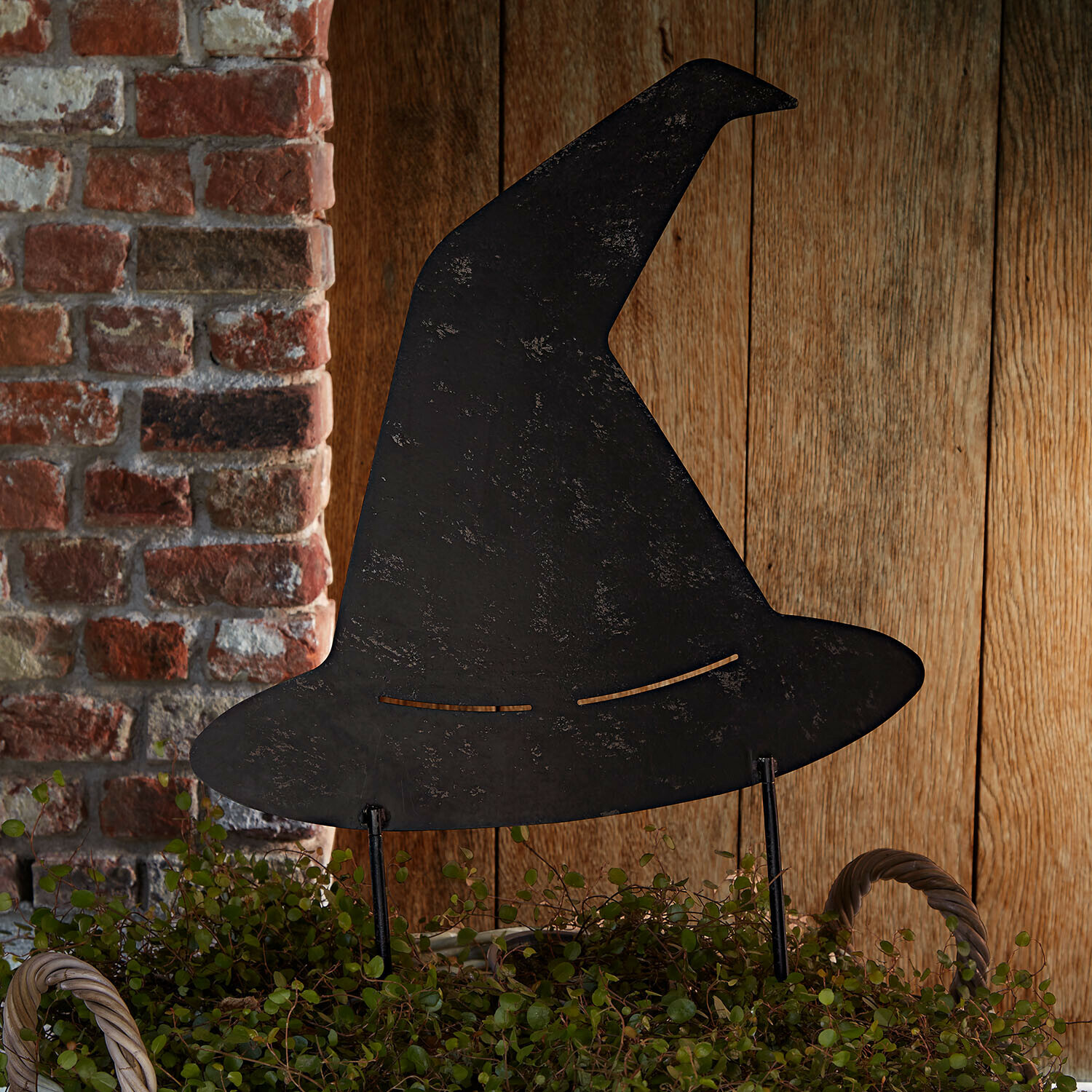 Pique de jardin Donvara Chapeau de sorcière en métal noir décoratif sur fond de mur en briques et bois, décoration Halloween