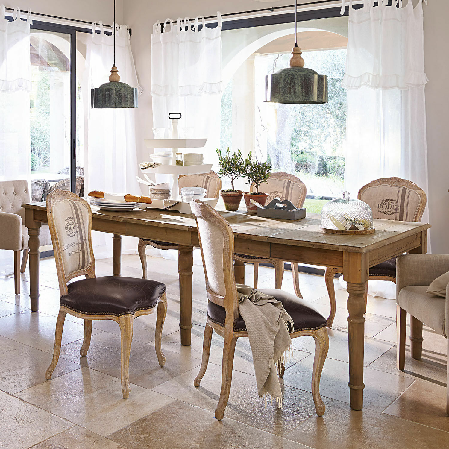 Table Bergenfield Salle à manger avec table en bois et chaises vintage en cuir marron dans un intérieur lumineux
