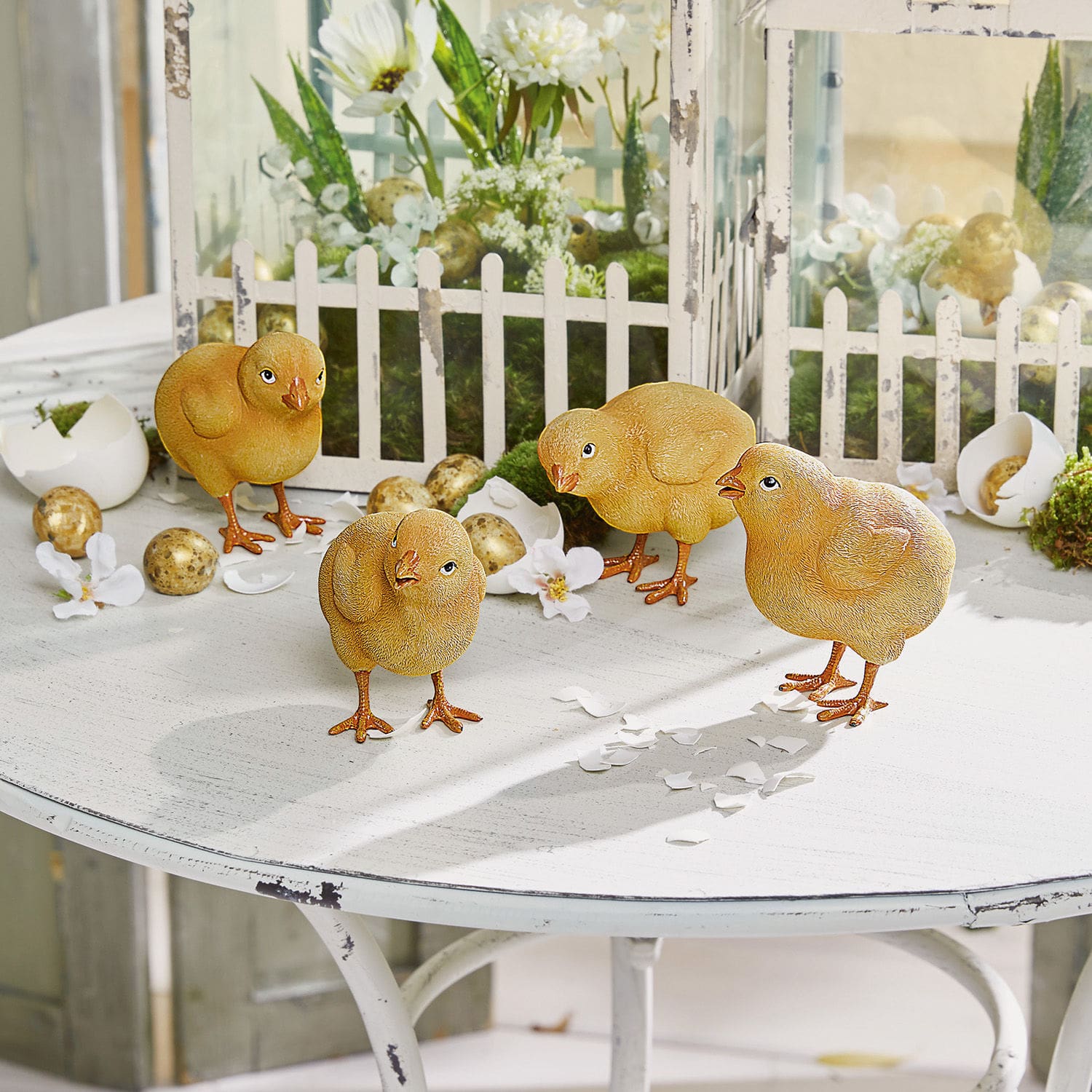 Lot de 4 poussins Wendolin Quatre poussins décoratifs jaunes sur une table blanche avec décorations de Pâques et œufs artificiels